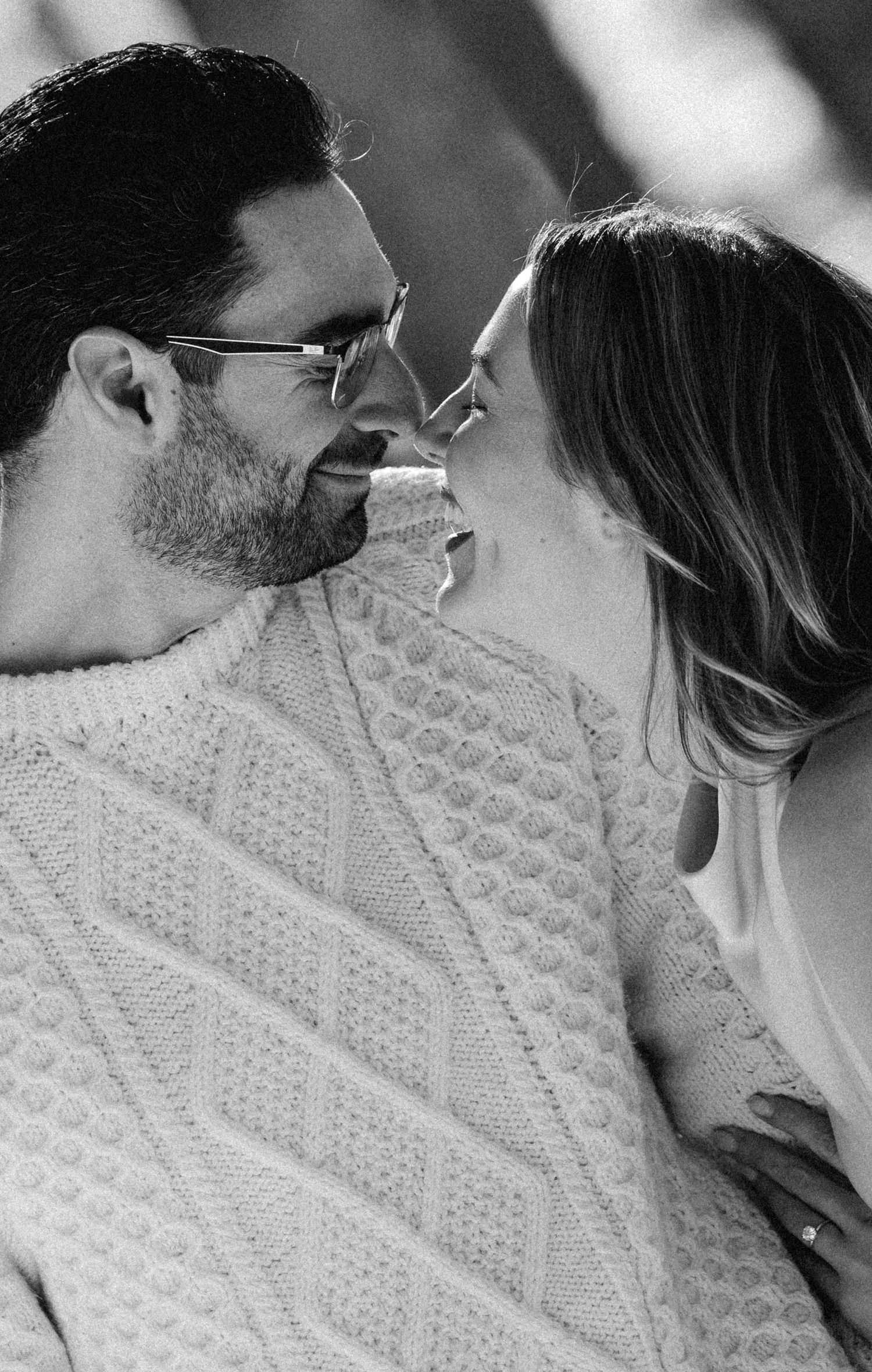 Romantic black and white close-up of a couple in a cable knit sweater.