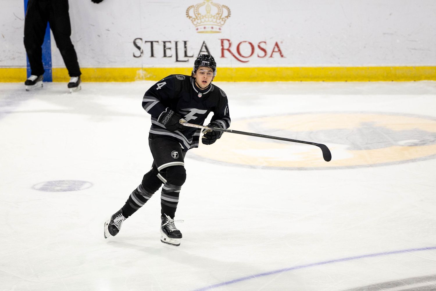 Hockey players skating on ice during a game at Stella Rosa arena.