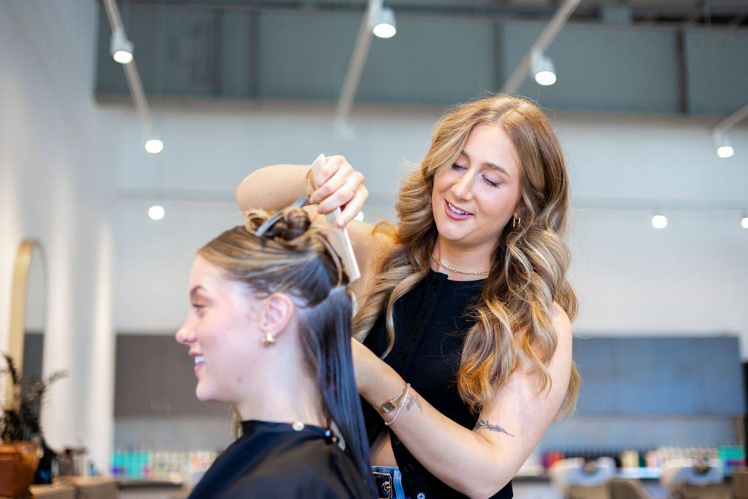 Hair styling session in bright modern salon with natural lighting.