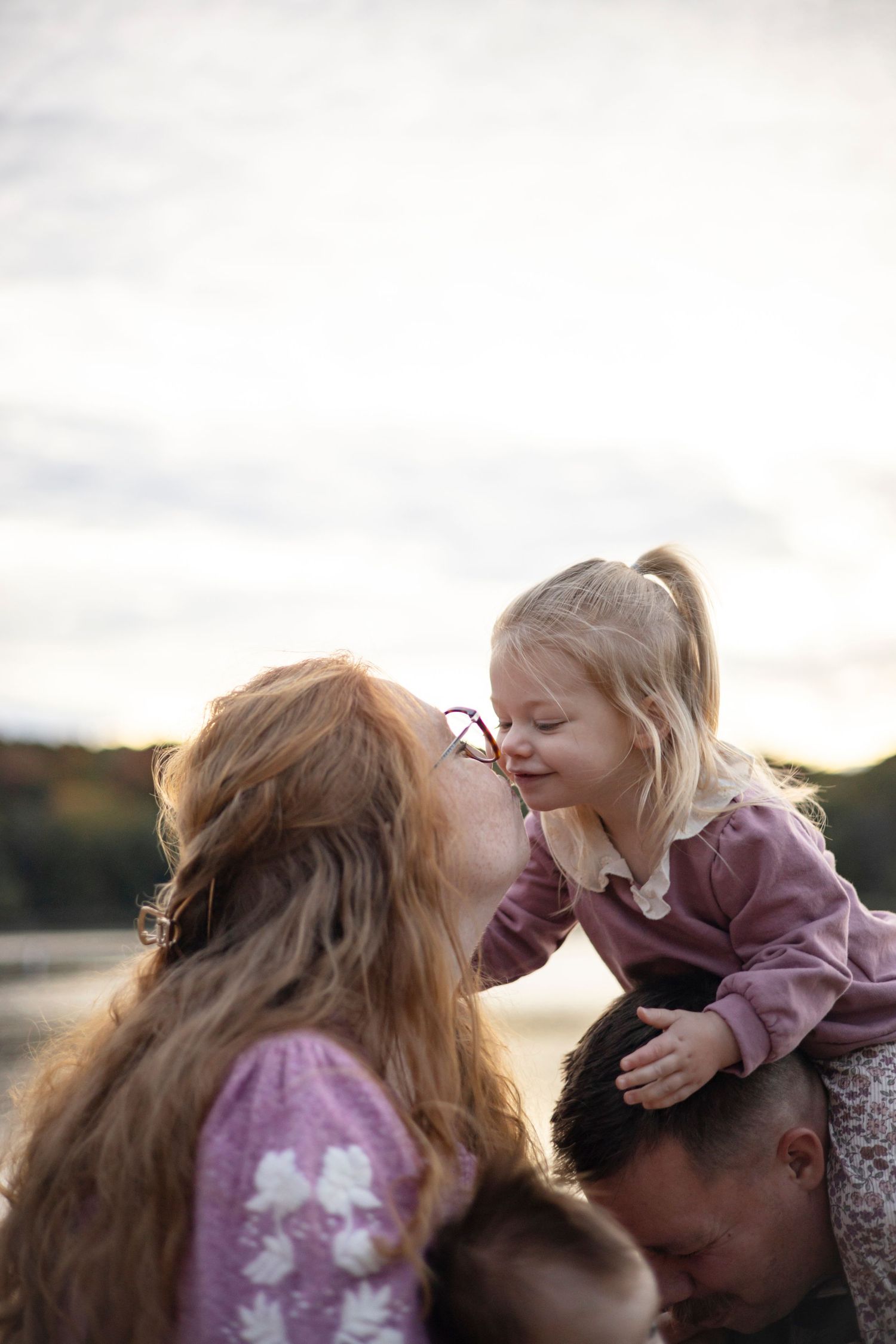 Joyful family sharing playful moments together during an outdoor photoshoot.