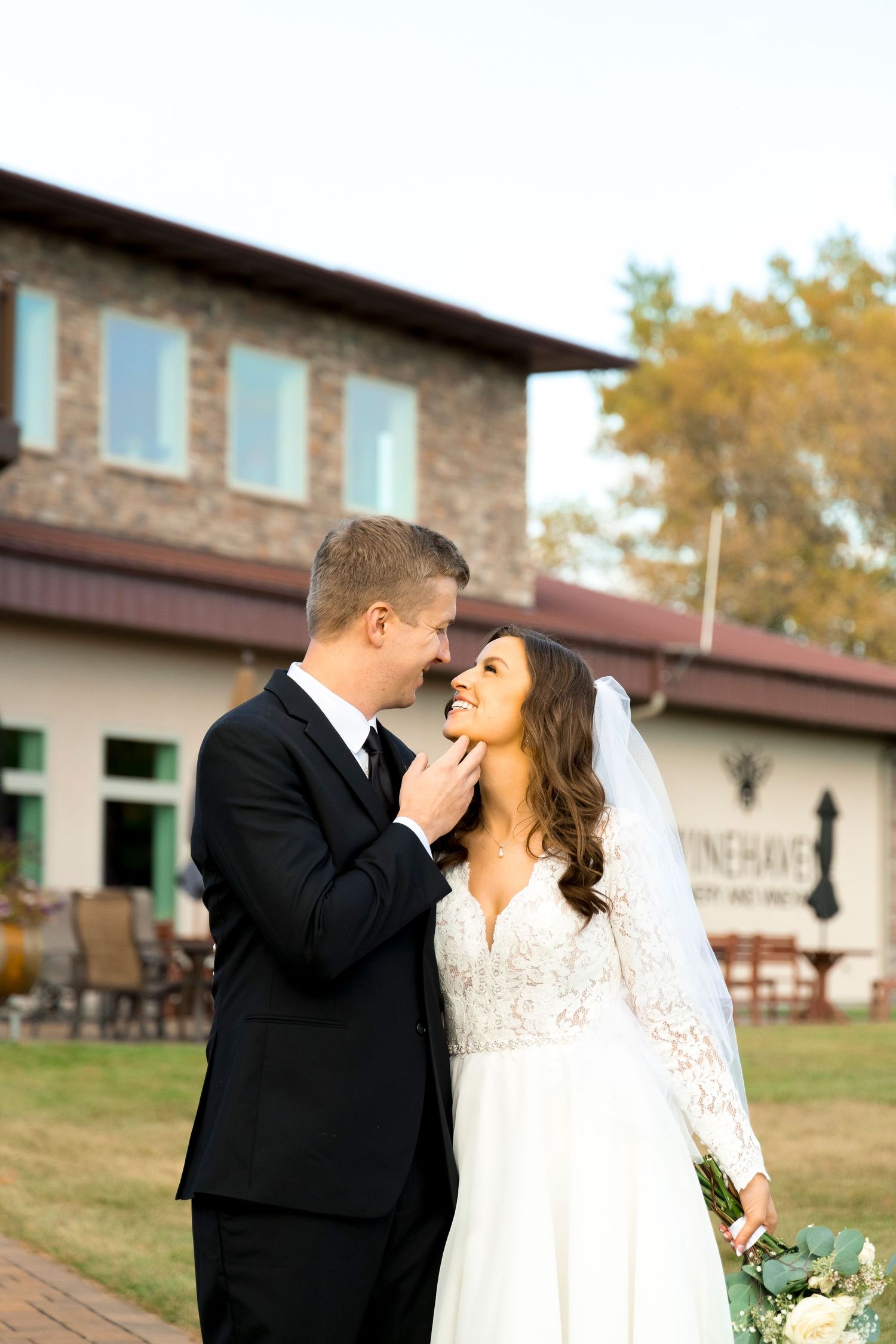 Wedding couple sharing intimate moments outside a rustic stone building.