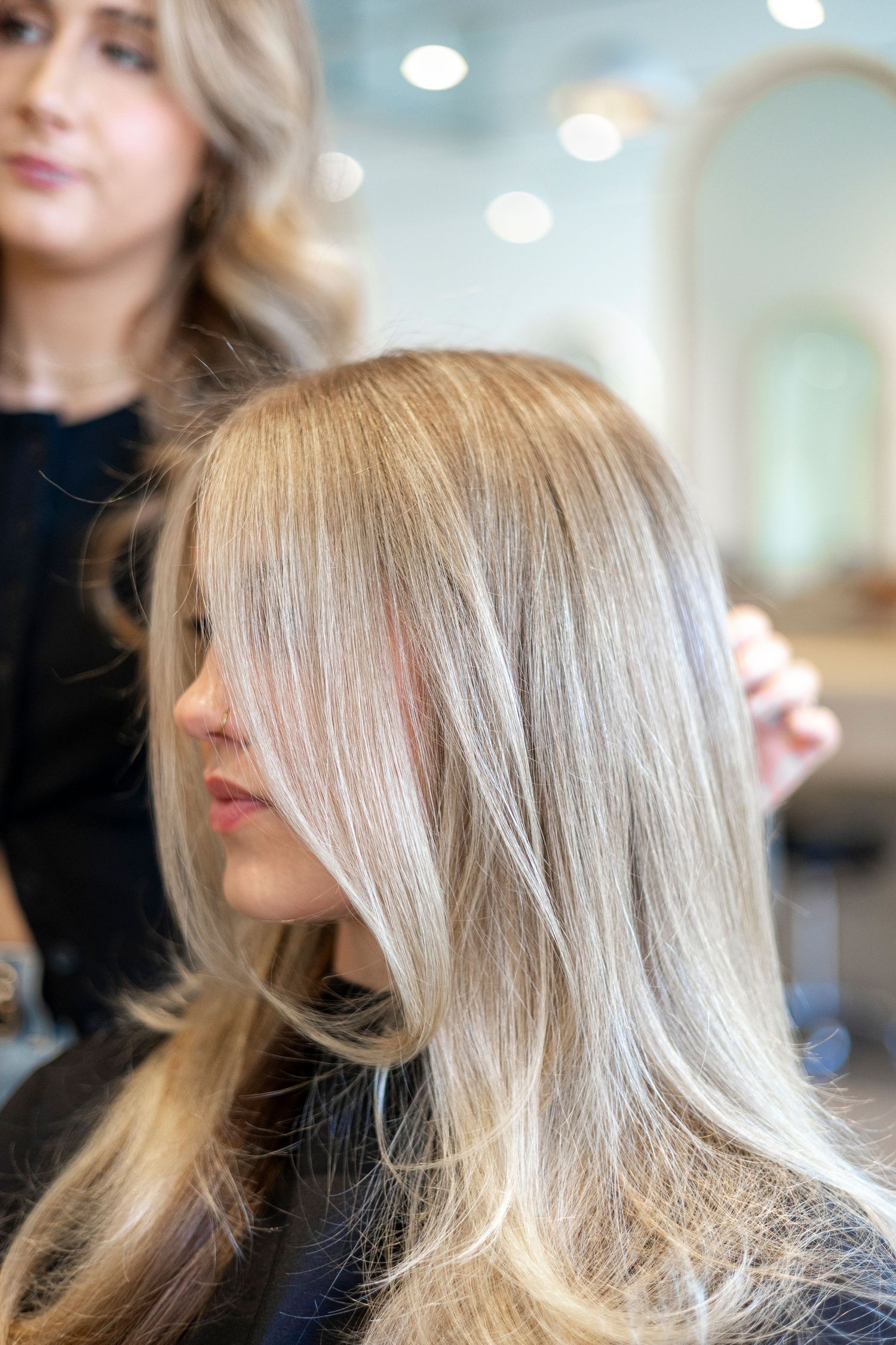 Professional blonde hair styling session showing layered cut technique.