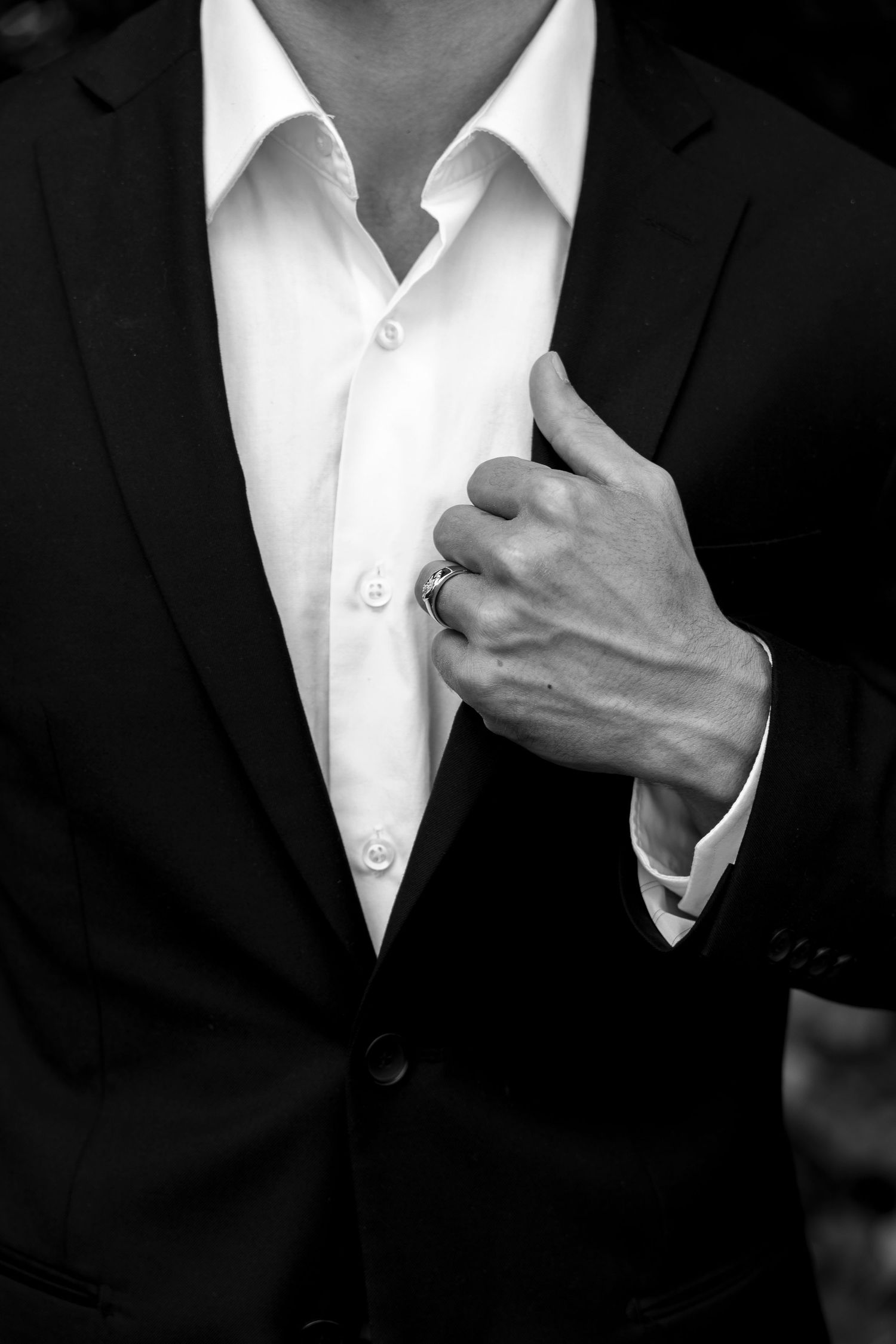 Close-up details of a formal black suit jacket and white dress shirt.