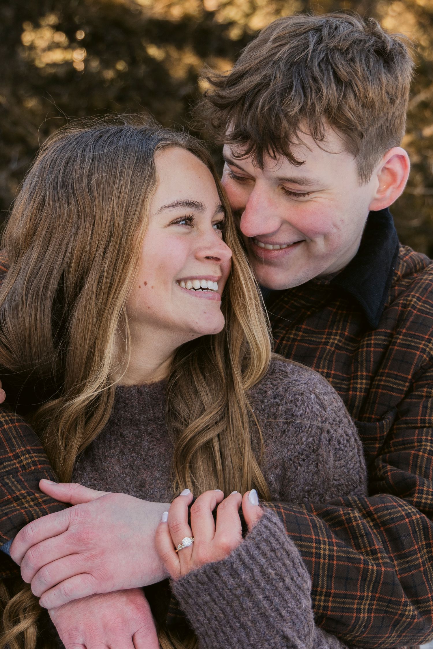 An intimate couple shares a tender moment while wrapped in warm sweaters.