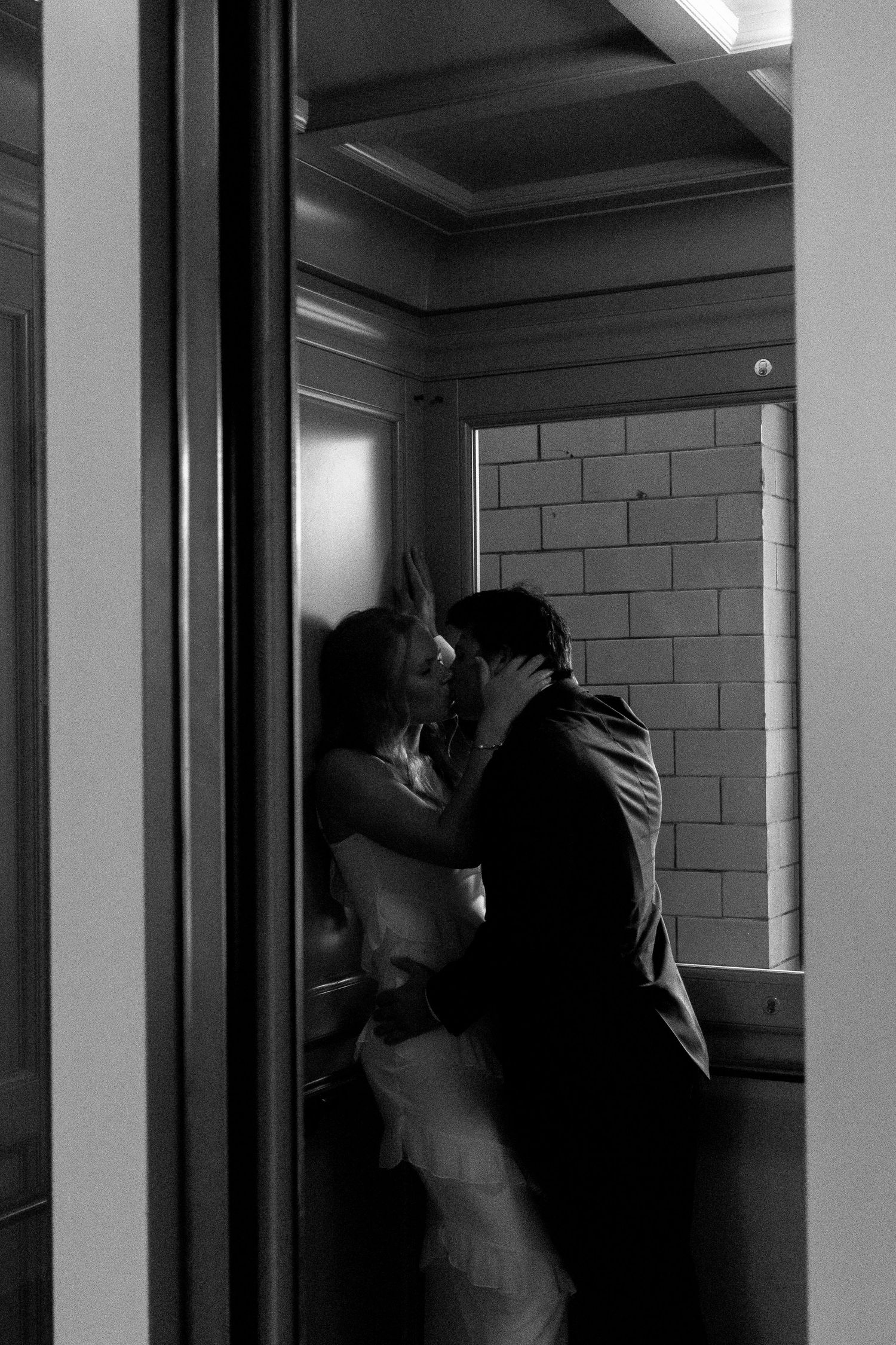 Dark silhouettes against white walls in an institutional hallway setting.