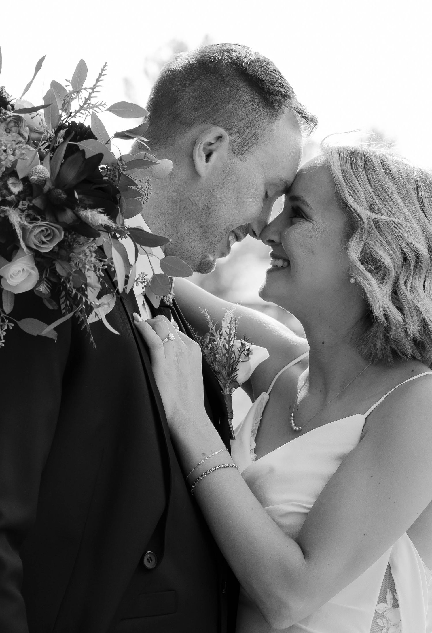 Intimate black and white portrait of newlyweds sharing a romantic moment.