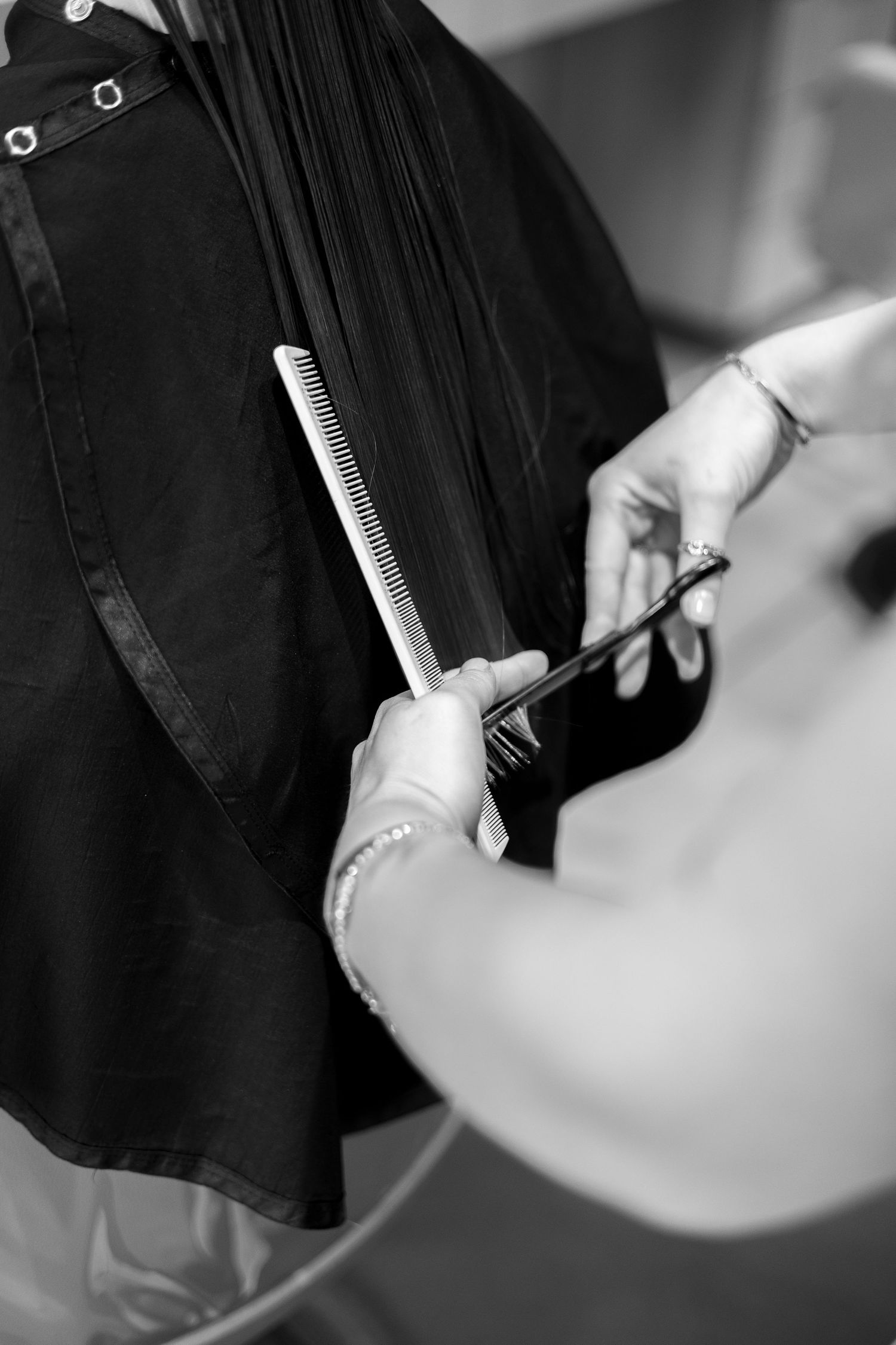 Close-up black and white shot of hair being styled with a comb.