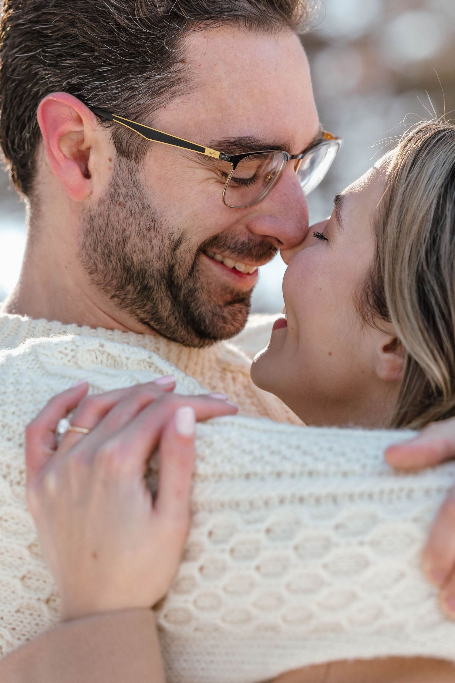 Intimate moments captured through a white knit blanket with detailed patterns.