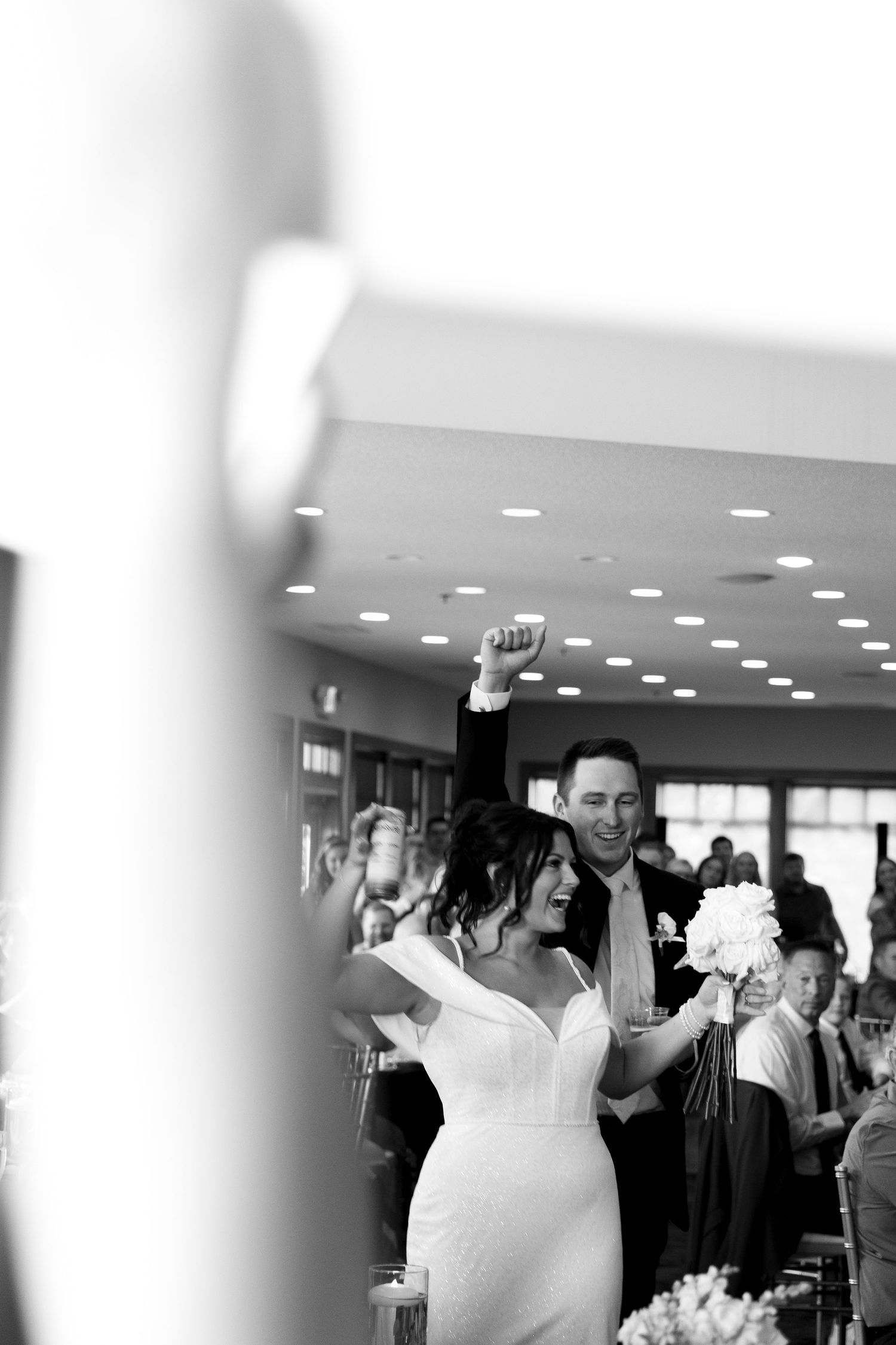 Wedding reception celebration in an indoor venue with overhead lighting.