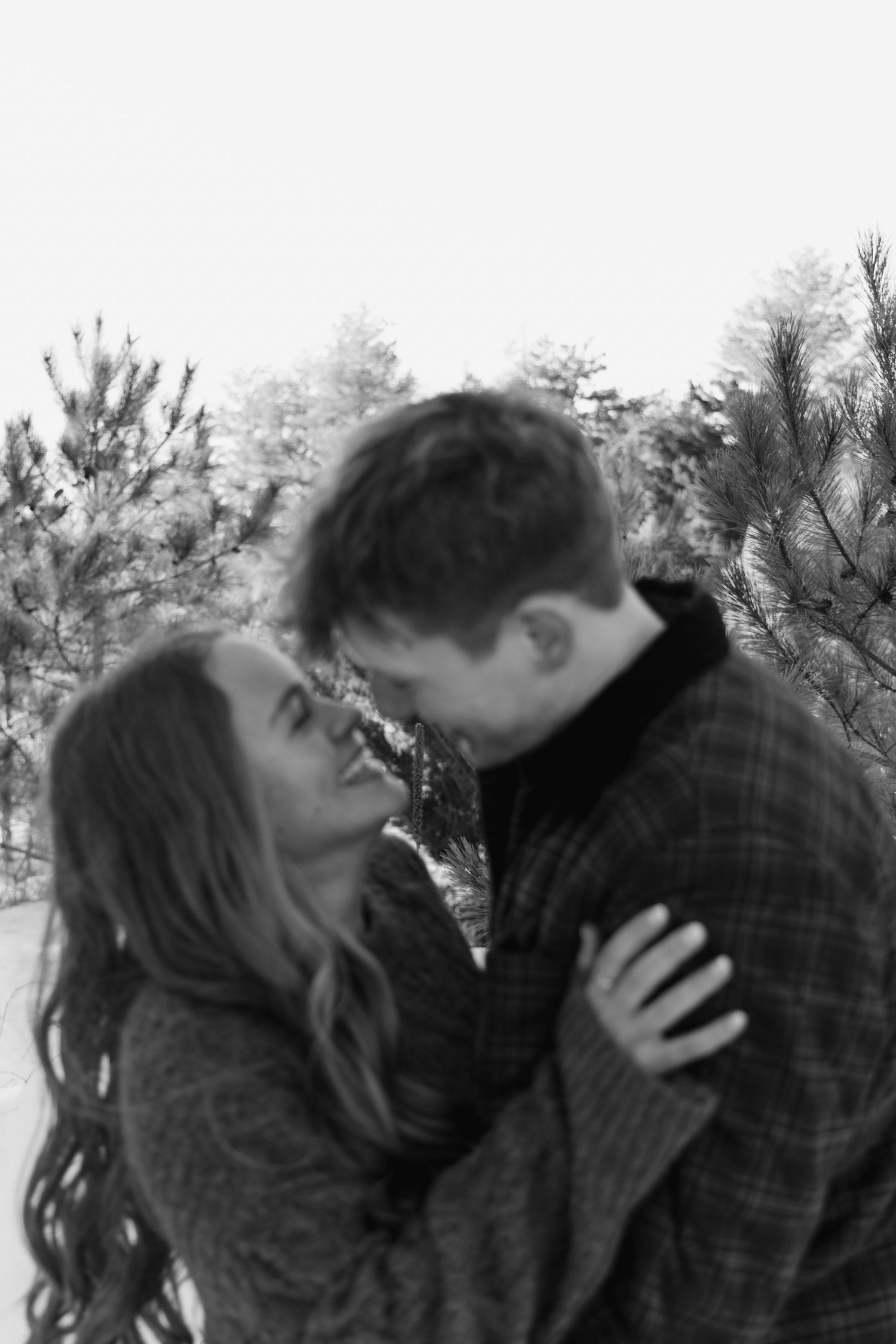 A romantic black and white photo sequence showing a couple sharing tender moments outdoors.