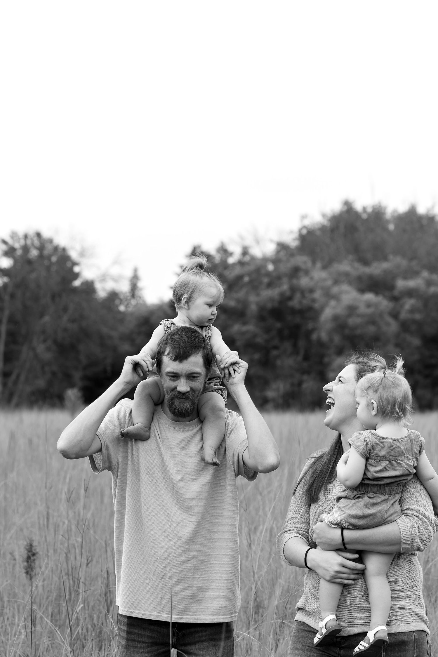 Black and white sequence of joyful moments between adults and child outdoors.