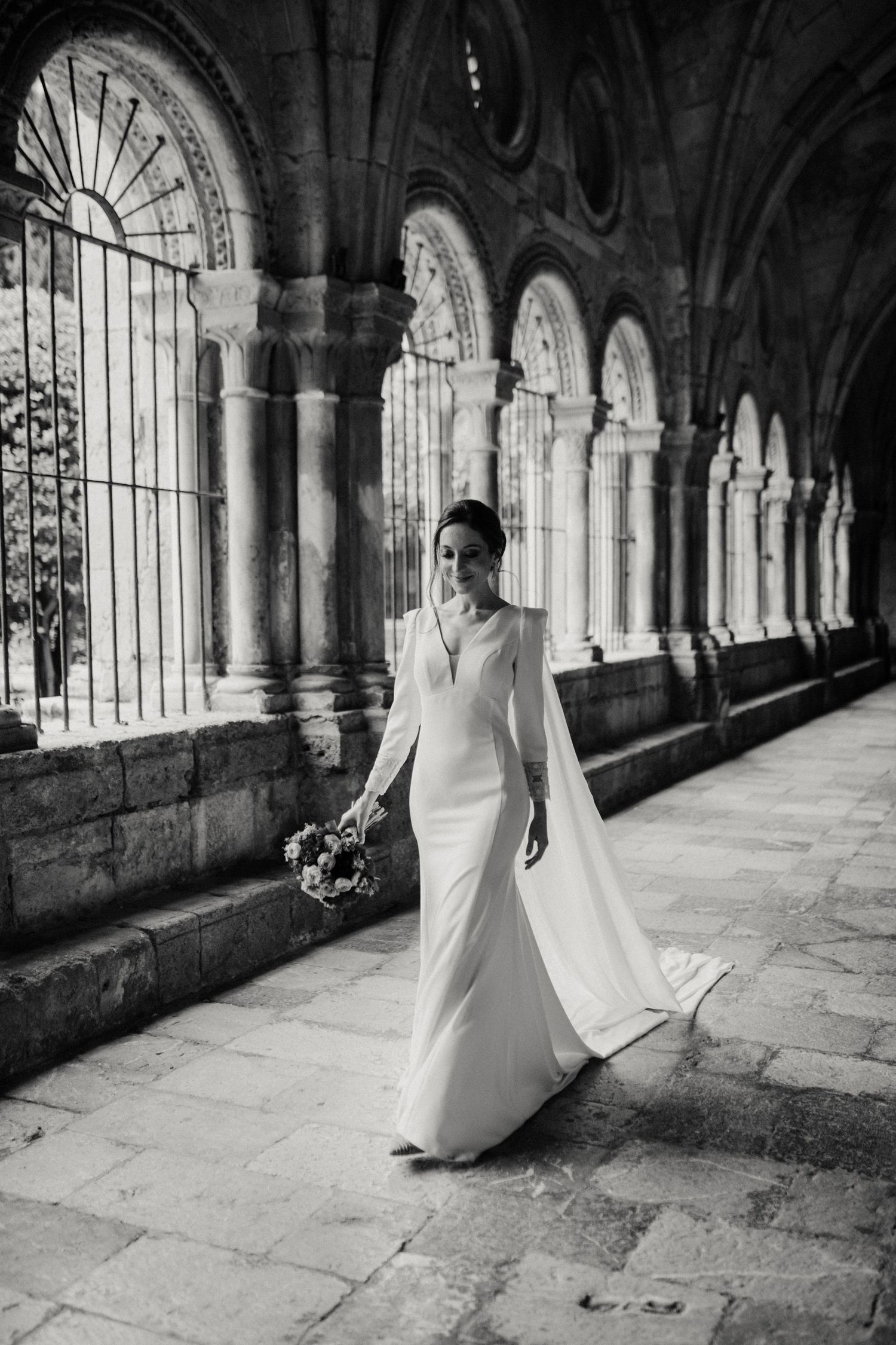 Novia caminando en el claustro de Tarragona en fotografía de boda en blanco y negro