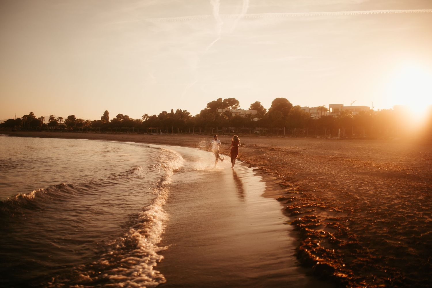 Sesión preboda en la playa en Tarragona con pareja corriendo al atardecer