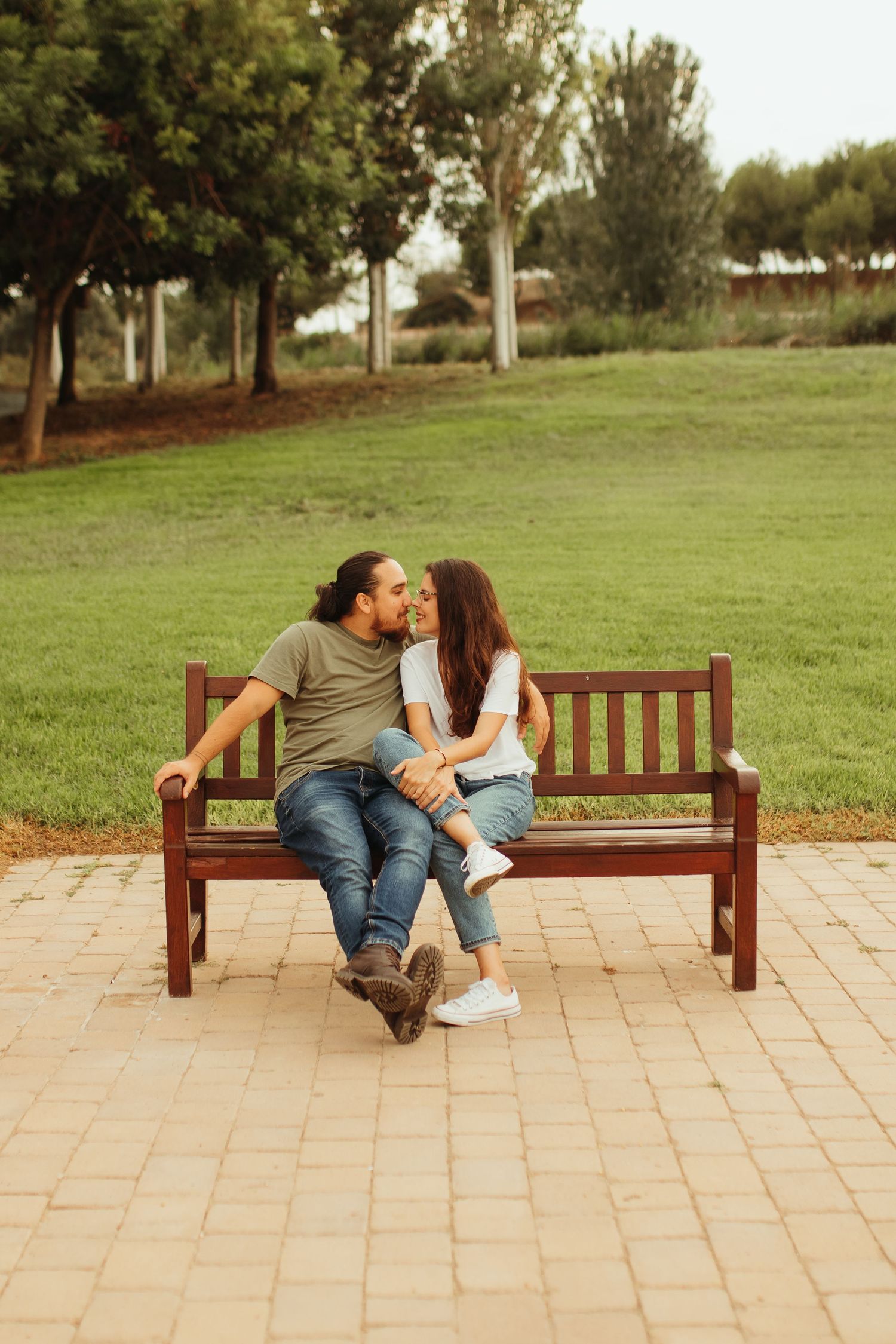 Pareja sentada en un banco mirándose durante sesión preboda en Tarragona