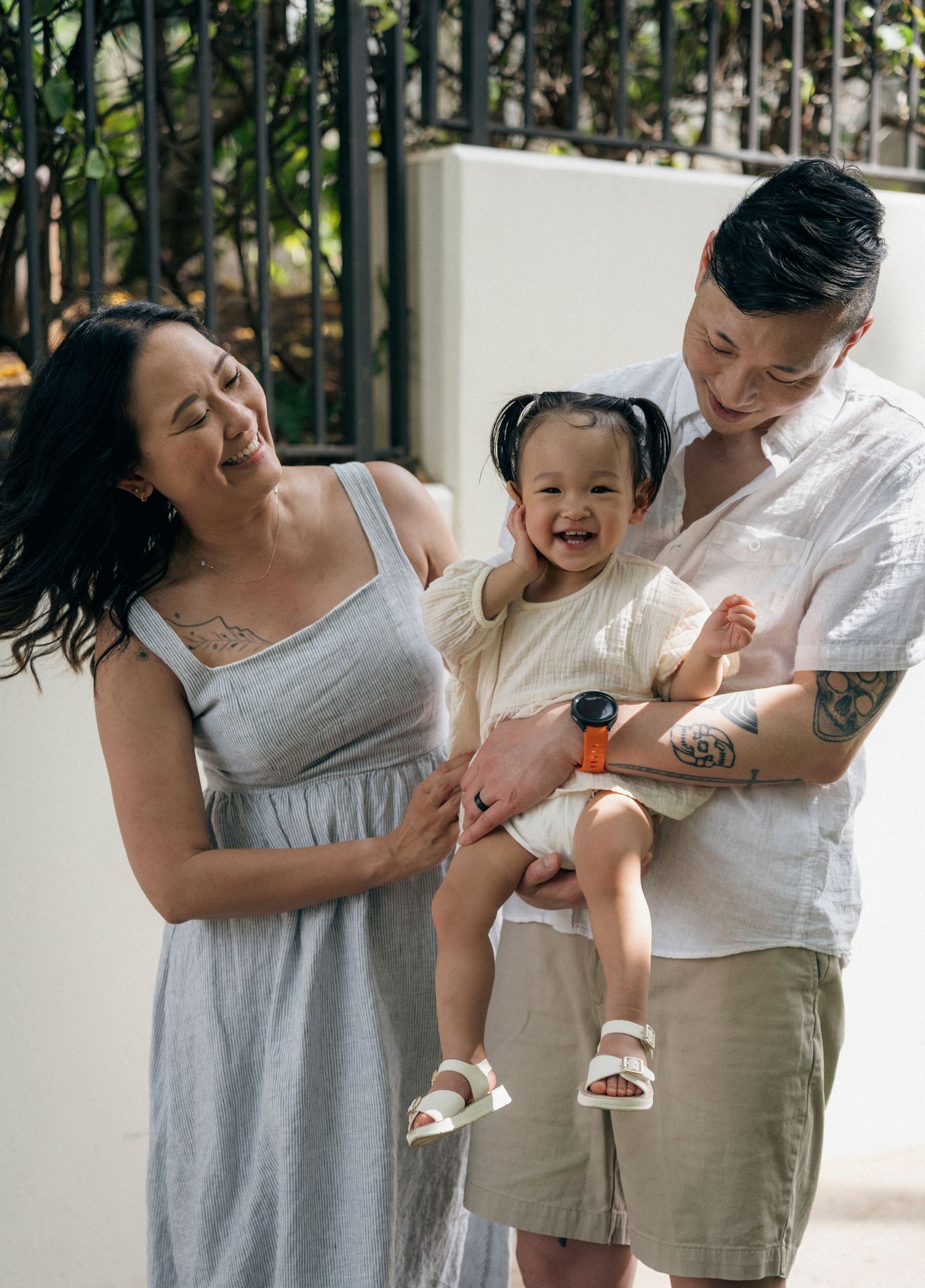 A candid family moment captured outdoors with natural lighting and greenery at Ko Olina