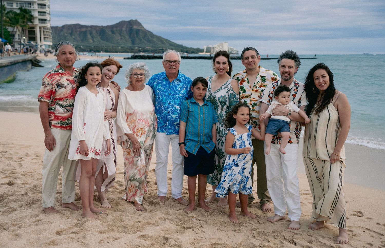 Group beach portrait with Diamond Head mountain and Waikiki skyline in the distance.
