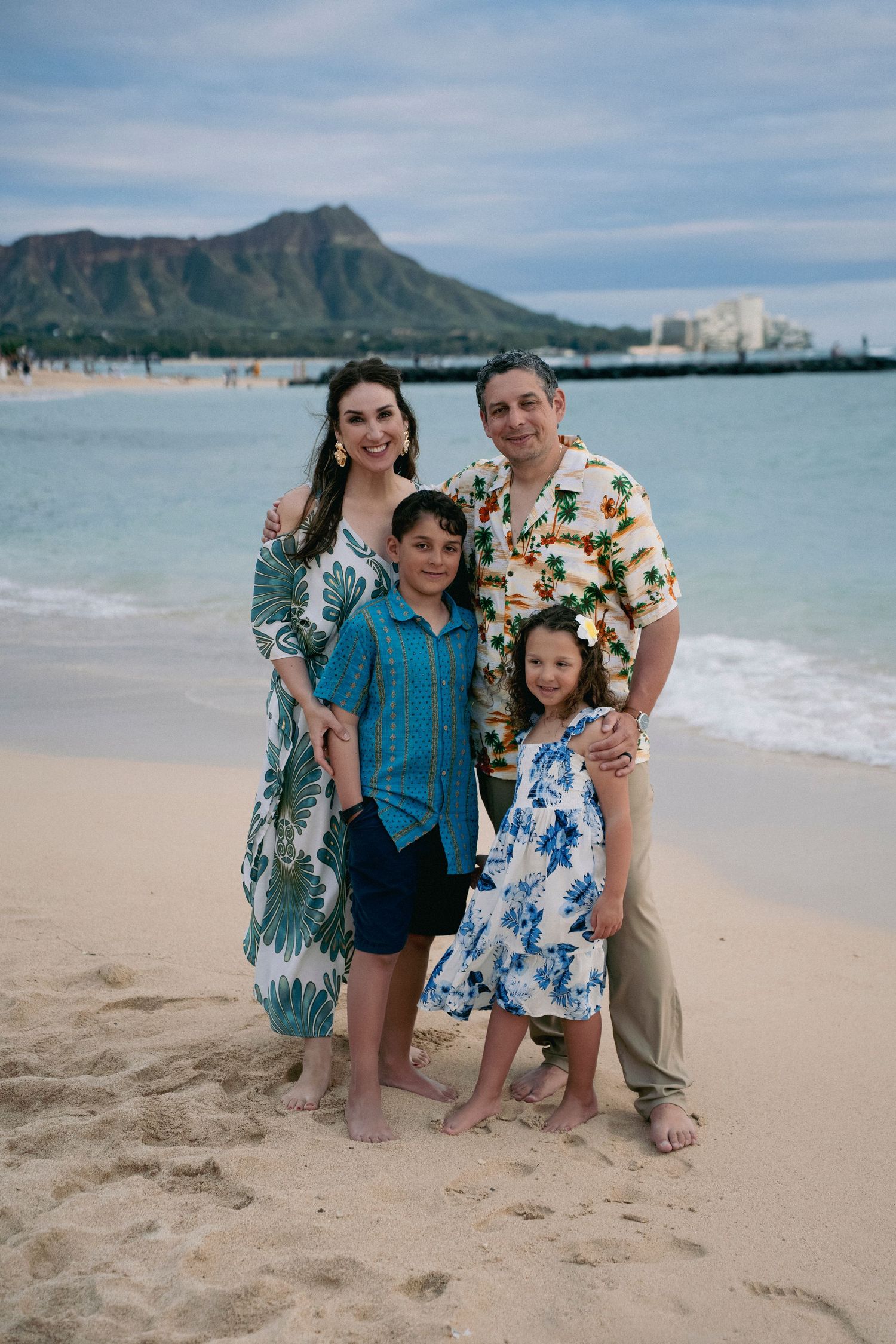 Family portrait session on Waikiki Beach with Diamond Head mountain visible in the background.