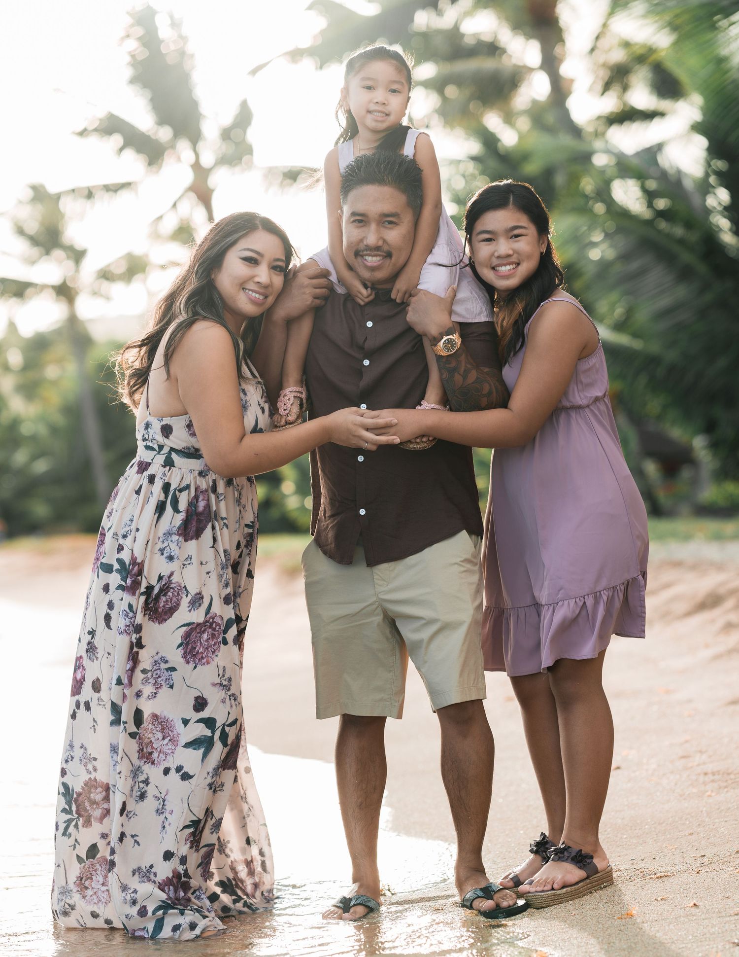 Candid beach photoshoot with family members interacting on the sand.