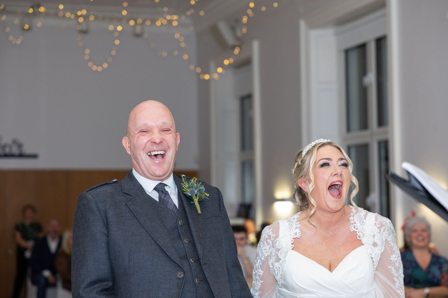 Wedding celebration in an elegant indoor venue decorated with string lights.