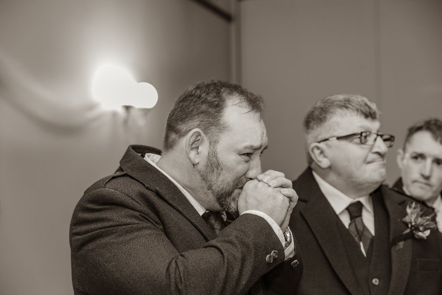 Black and white candid moment during wedding speeches at reception.