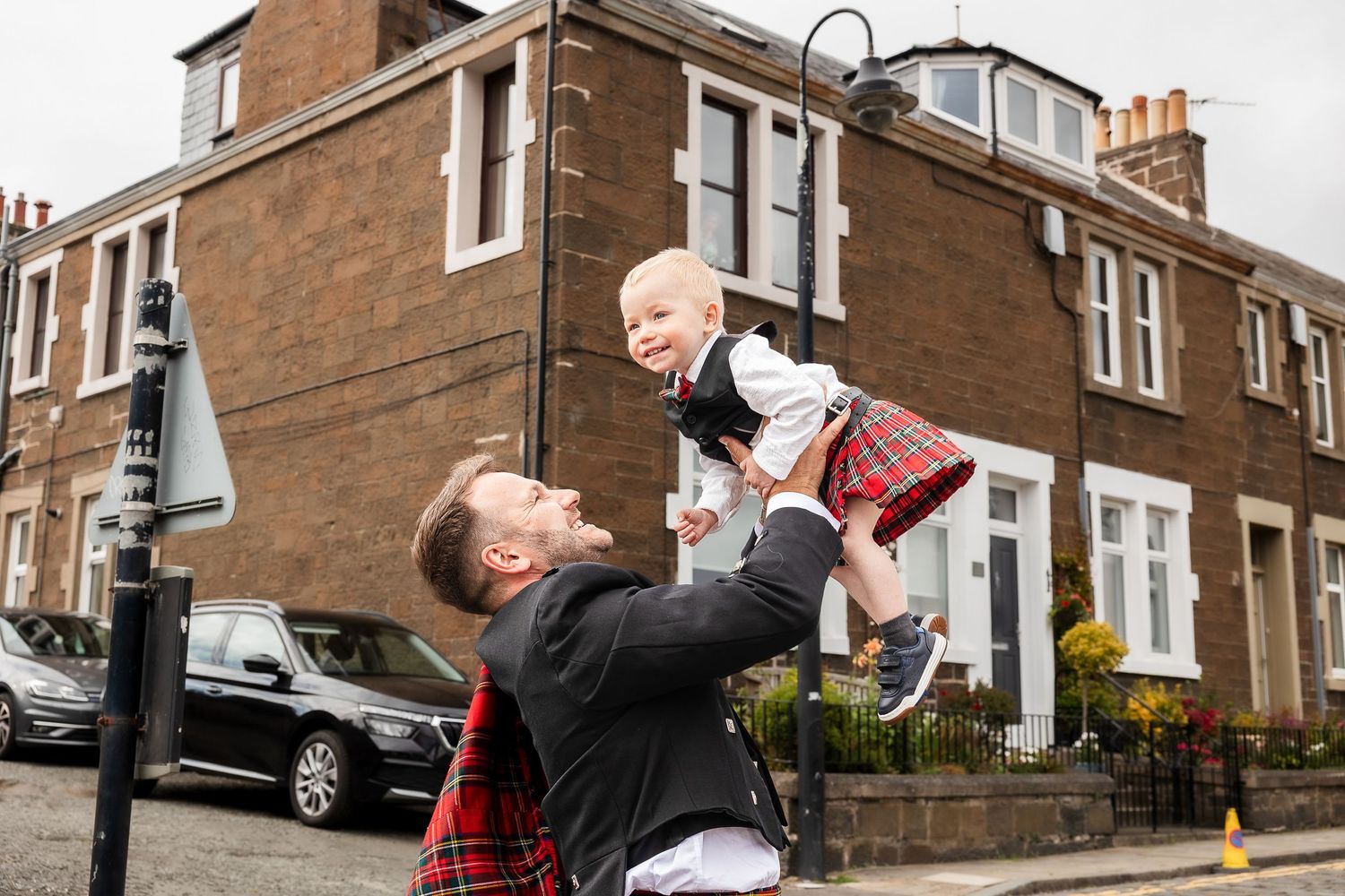 Wedding celebration on a residential street with traditional Scottish elements.