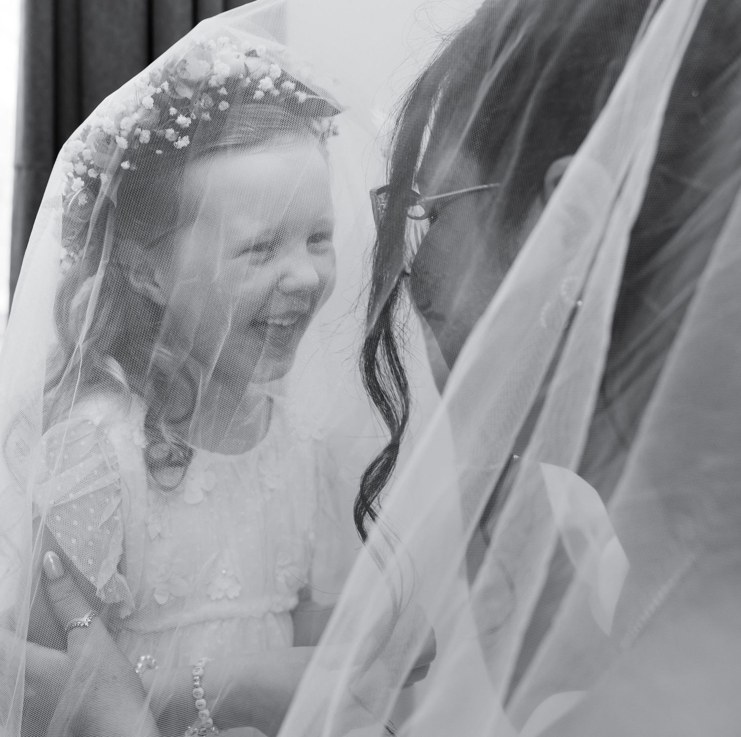 Black and white candid wedding moments captured through a delicate veil.
