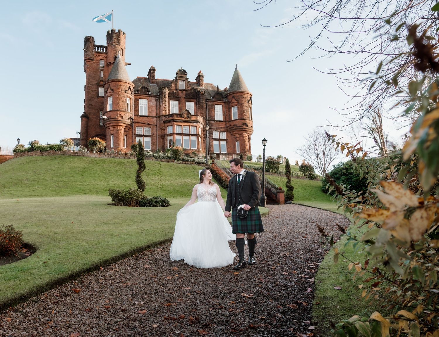 Wedding party walking along scenic path outside historic castle on autumn day. Sherbrooke Castle
