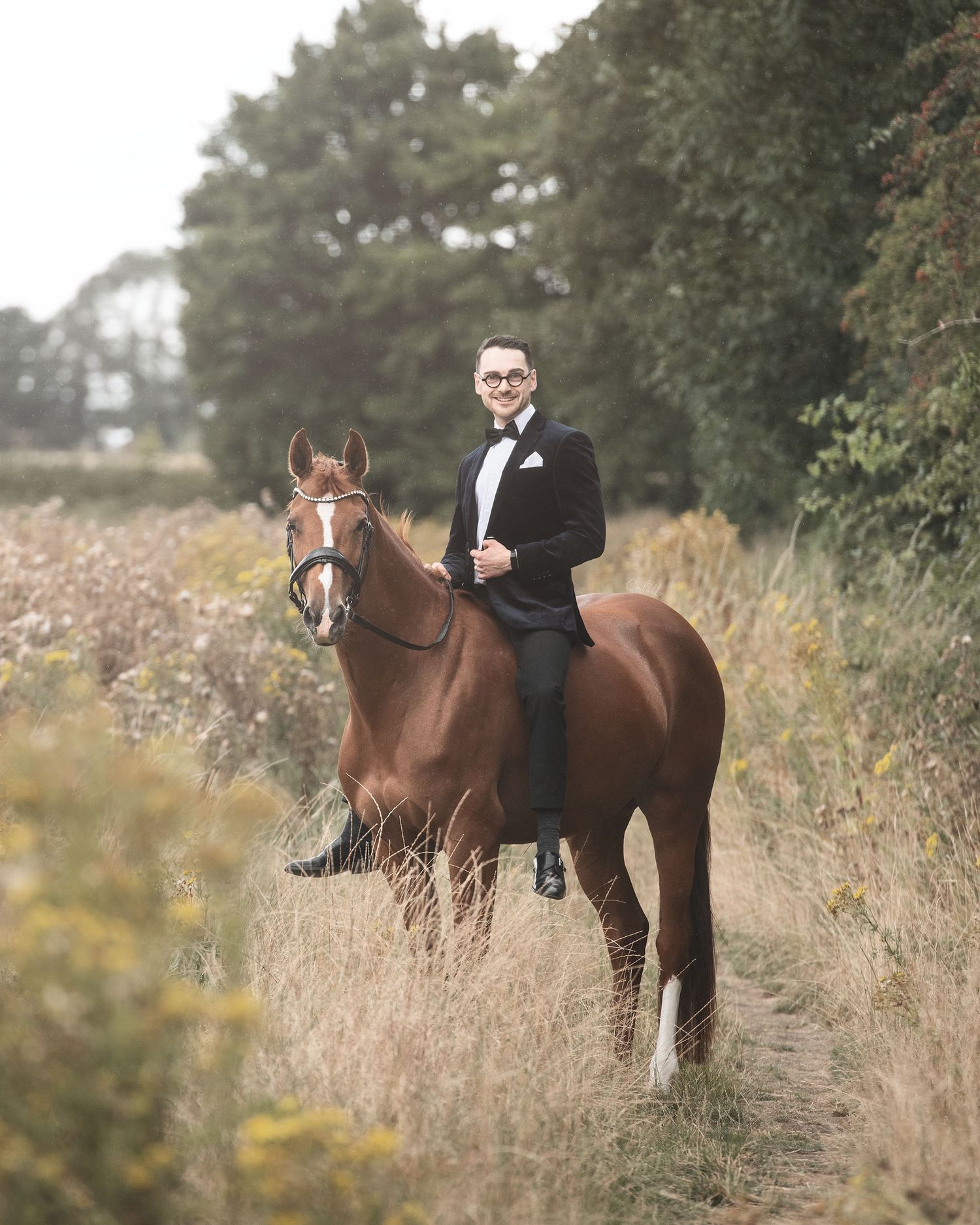 Formal equestrian portrait in autumn field with tall grass in the rain with fitness influencer & rider coach Karzan Hughes and his mare Lily
