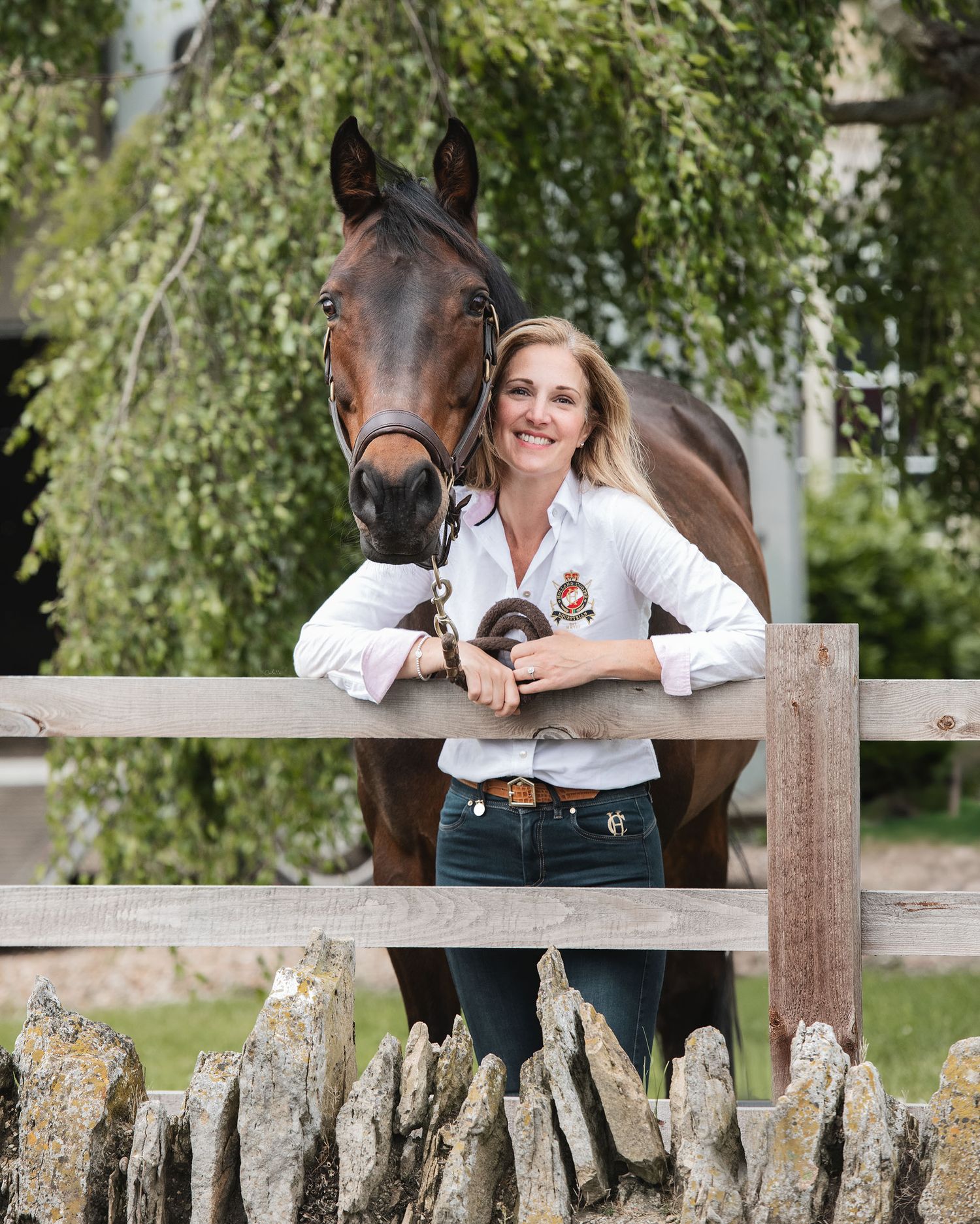 Horse and rider standing by rustic wooden fence with weeping willow tree. Rider has retired her &wanted to shoot at home for the memory.