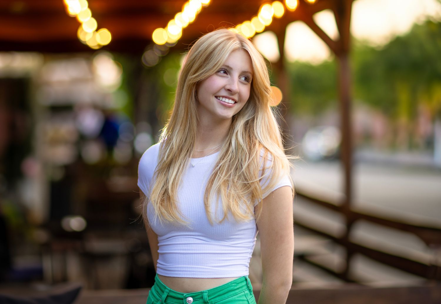 Summer portrait session outdoors with urban background and natural lighting.
