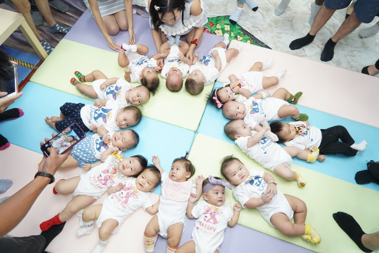 Group of children lying on colorful mats in a circle formation during a class activity.一群孩子在課堂活動中圍成一個圓圈躺在彩色墊子上。