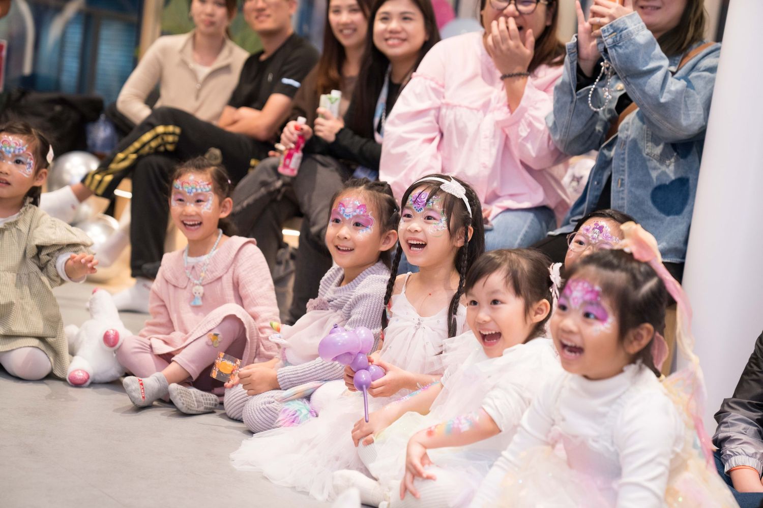 Young children in pink tutus and dance outfits perform together during a dance recital on stage.一群穿著粉紅芭蕾舞裙和舞蹈服的小朋友在舞台上進行舞蹈表演。