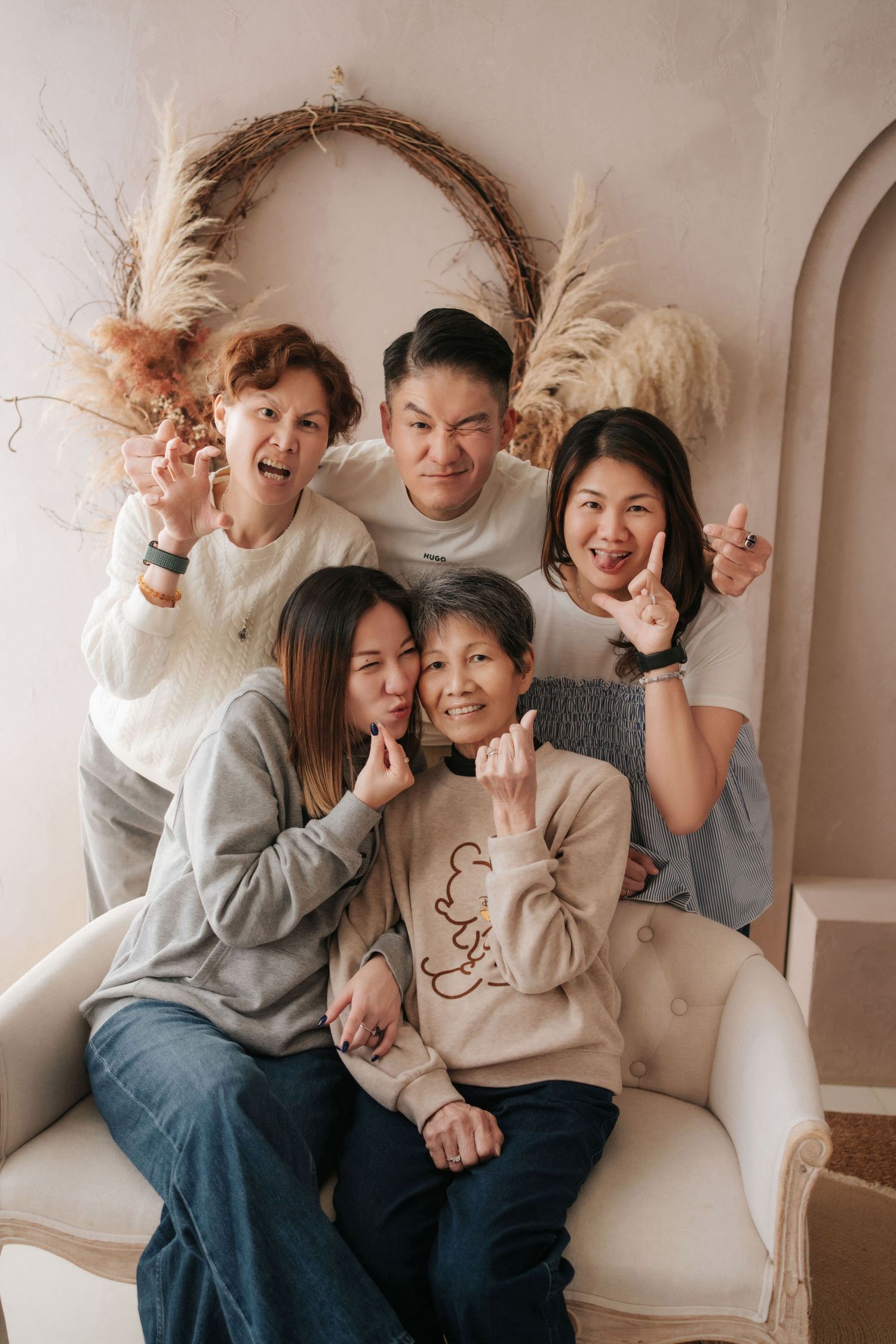 A family shares joyful moments together while relaxing on a white couch in a bright, minimalist setting.一家人在明亮簡約的白色沙發上放鬆身心，共享歡樂時光。