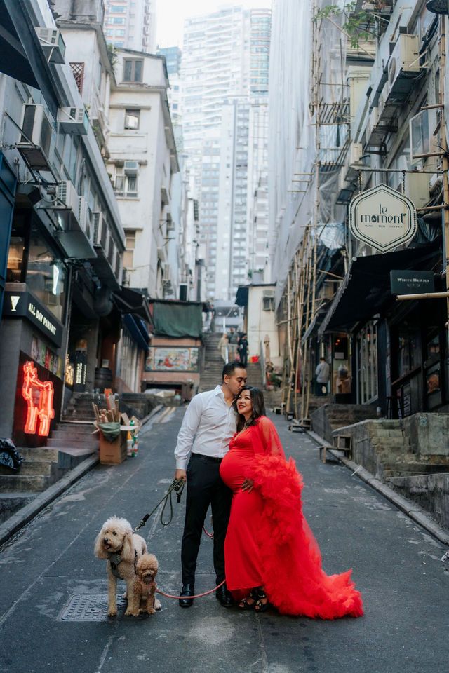 A series of four urban street photos showing a person in a flowing red dress posing with a dog on a cobblestone alley.