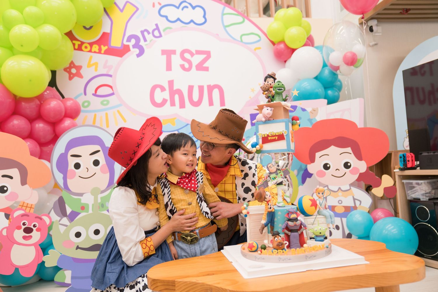 A colorful birthday party setup with Toy Story themed decorations, balloons, and a tiered cake on display.色彩繽紛的生日派對佈置，以《玩具總動員》為主題，擺放著氣球和多層蛋糕
