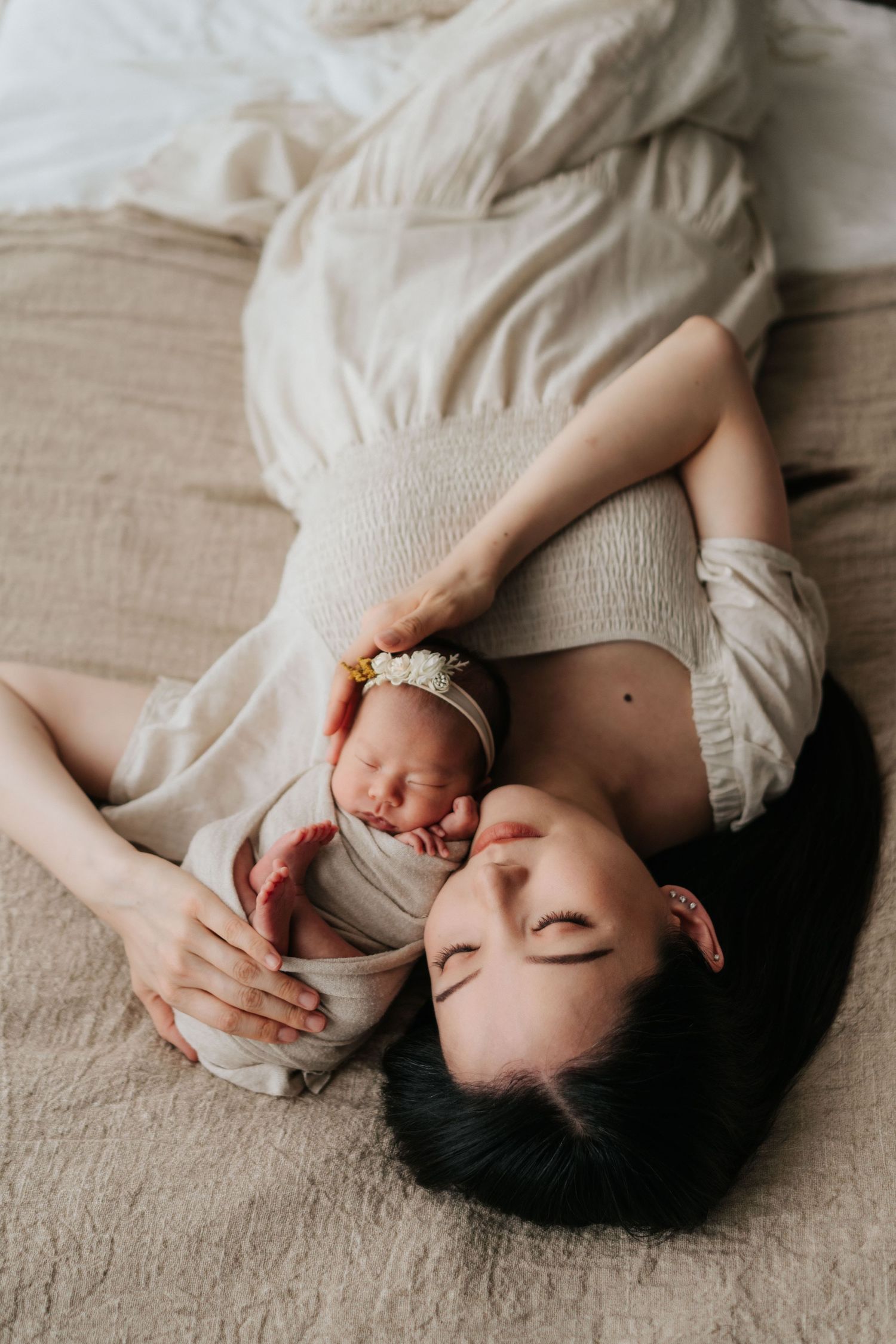A person in a white dress lies on a beige blanket while holding a cup of tea and relaxing.一位身穿白色洋裝的人躺在米色毯子上，手裡拿著一杯茶，放鬆地休息著。