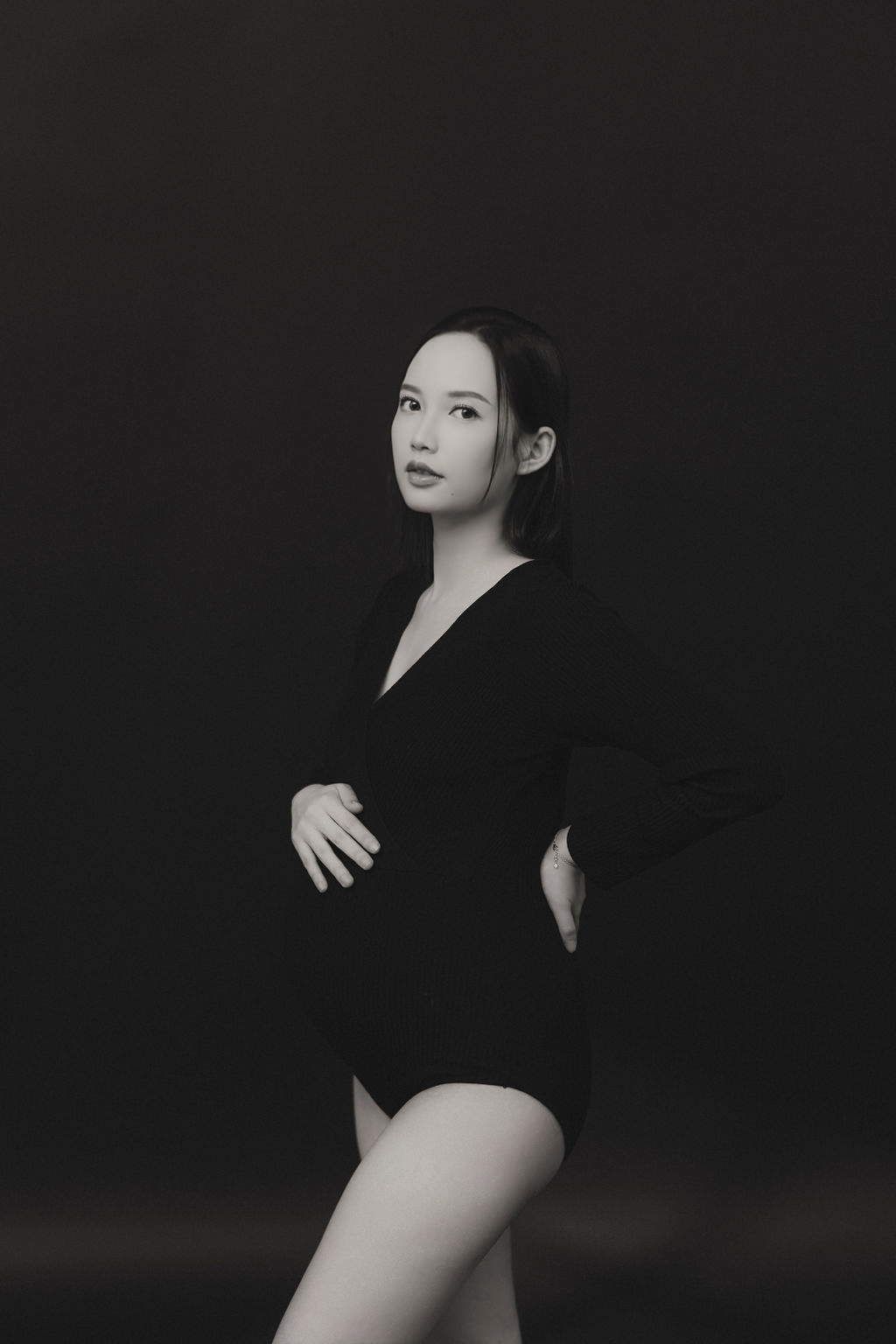 Artistic black and white portrait series showing a figure in dark clothing against a black background.
