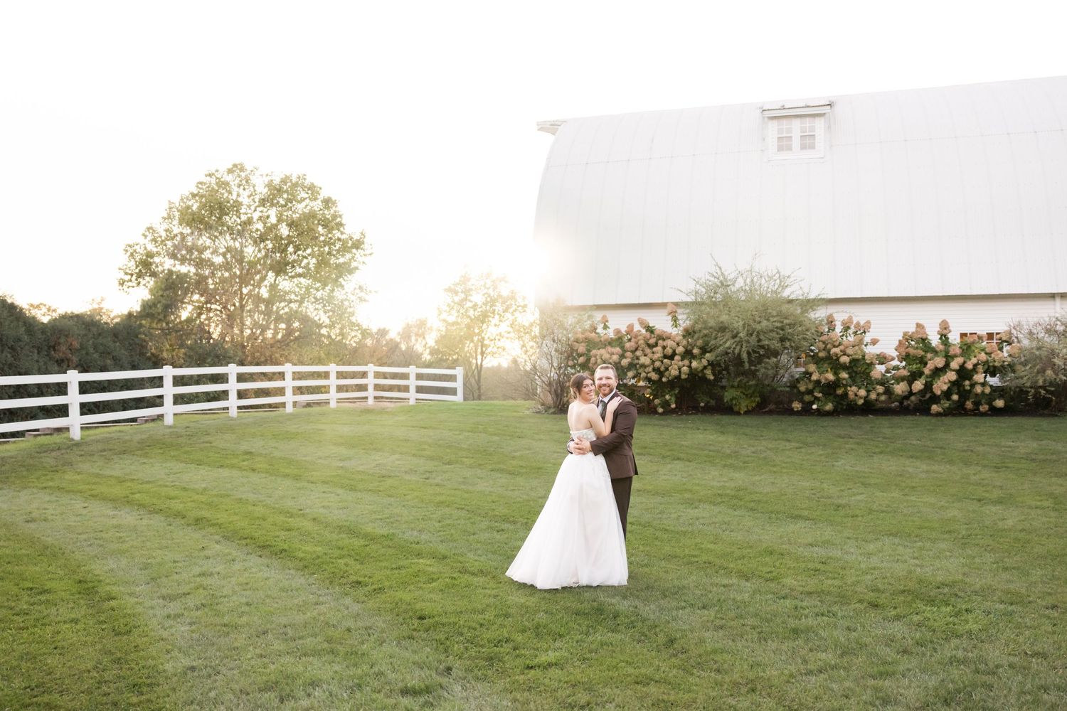 Wedding ceremony setup on a manicured lawn with white chairs and decorative elements.