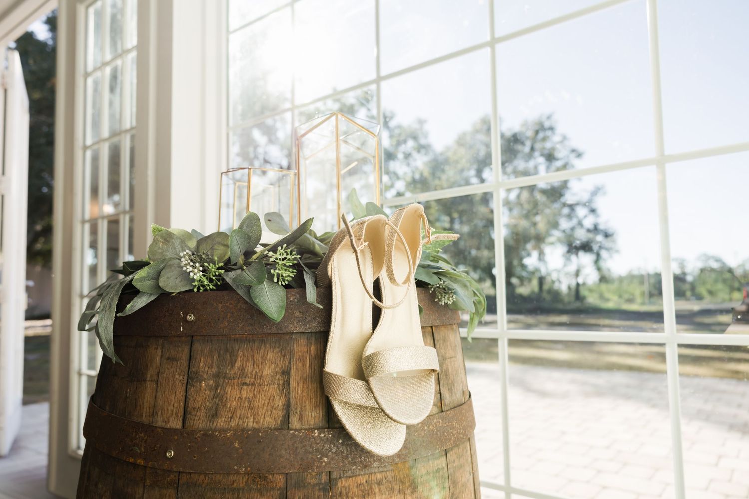 Wooden barrels and rustic decor arranged in front of large windows.
