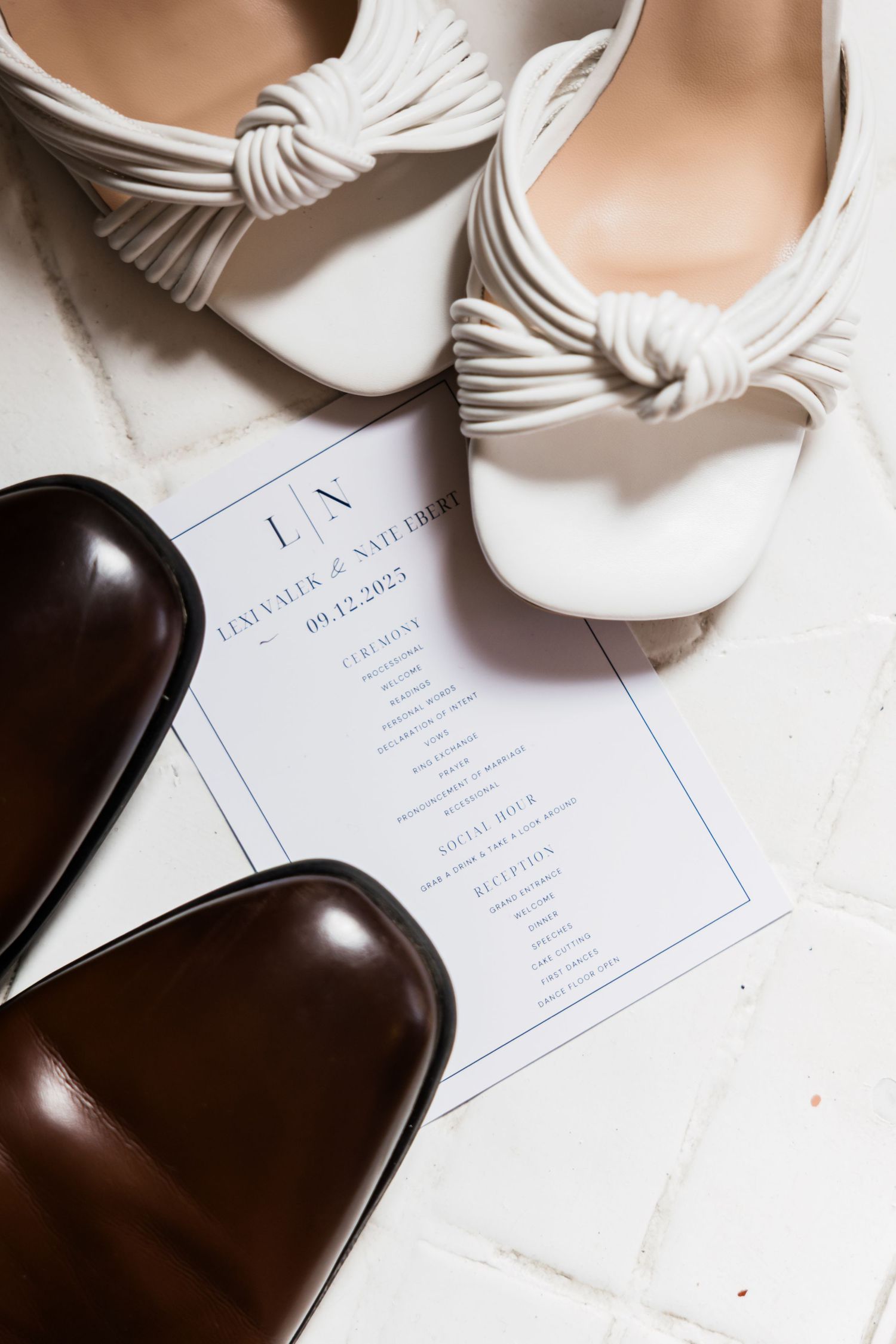 Wedding details including white bow accessories and invitation cards arranged on light background.
