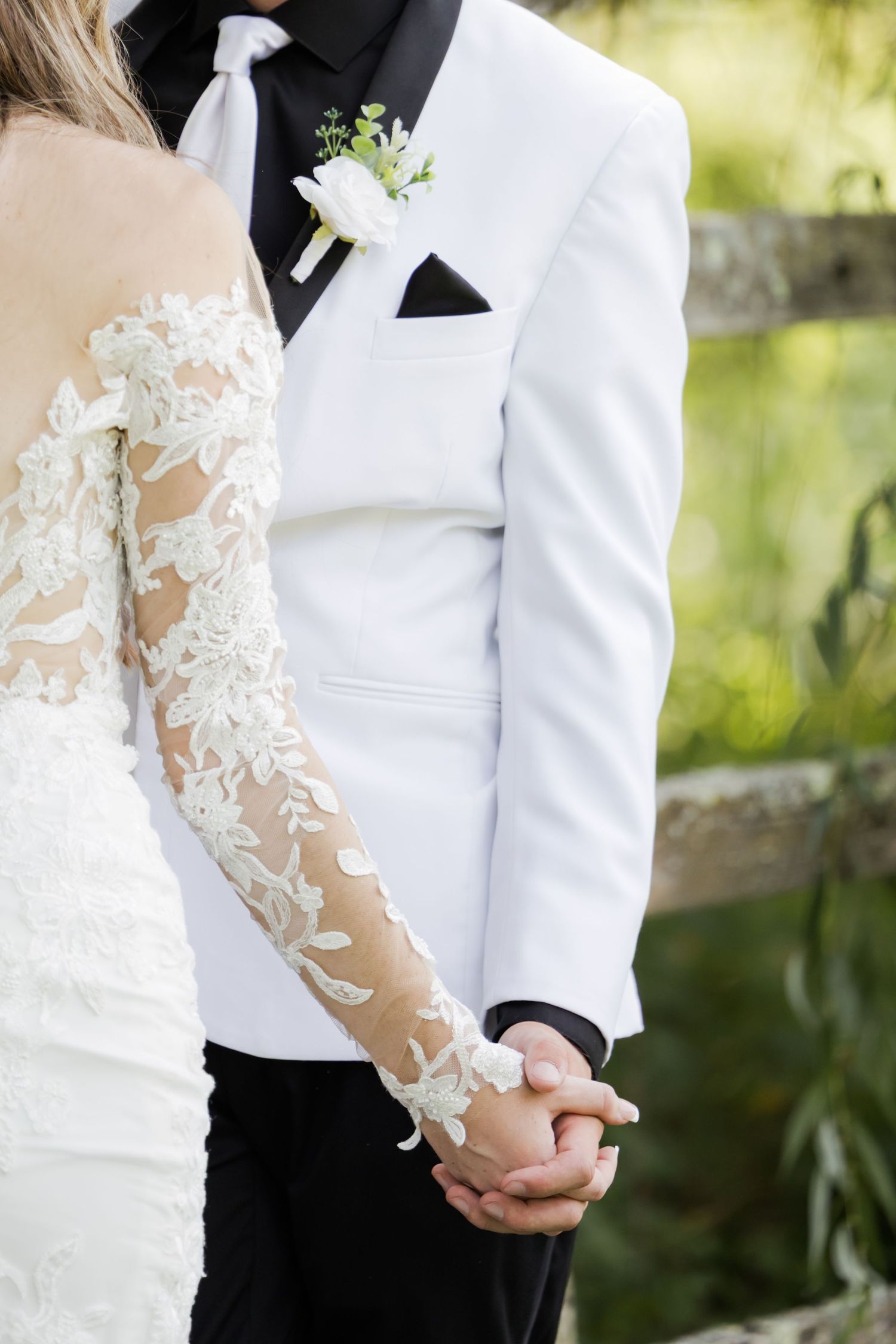 Close-up of wedding attire showing delicate lace details on white fabric.