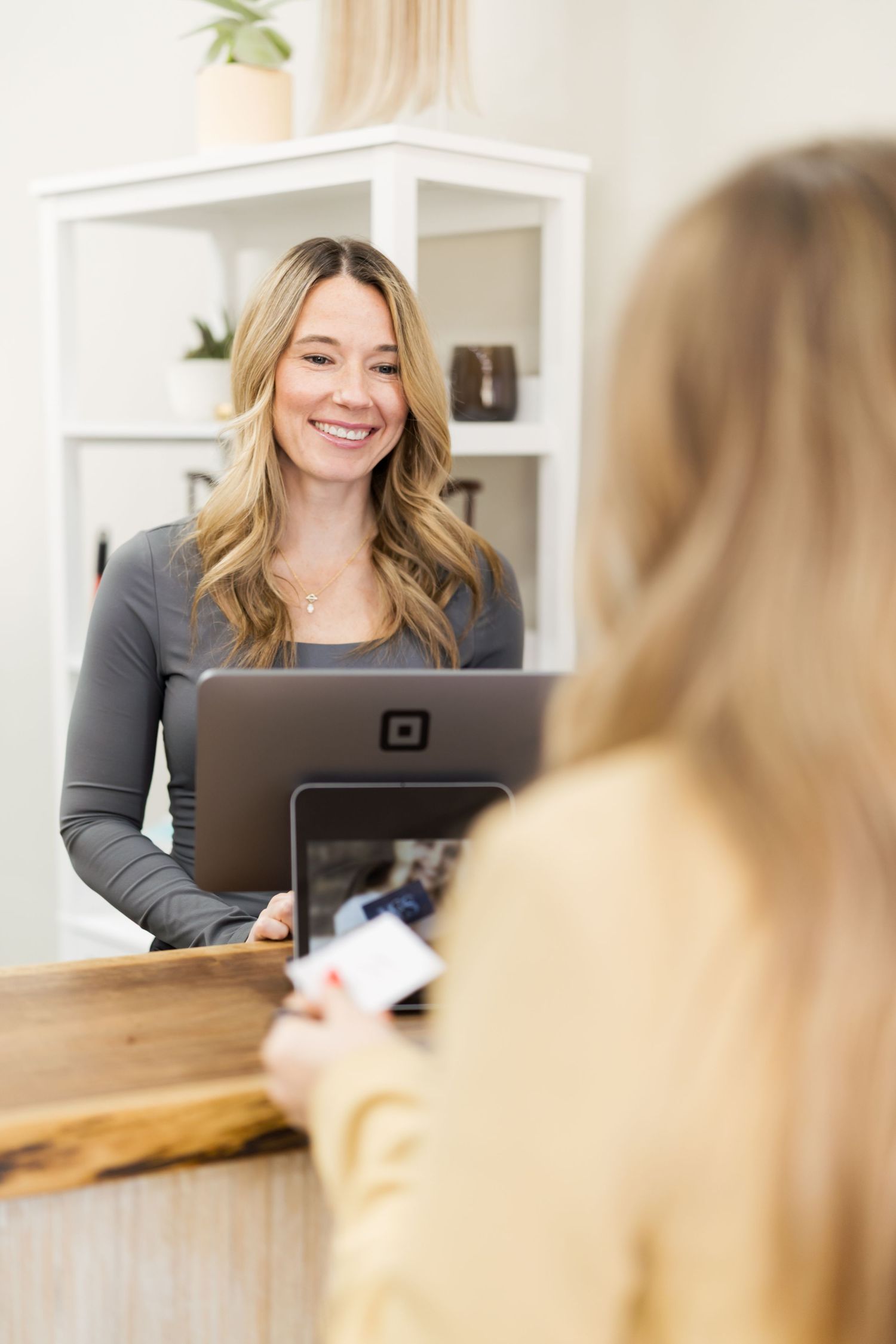 A professional working at a desk with a laptop in a bright modern office space.
