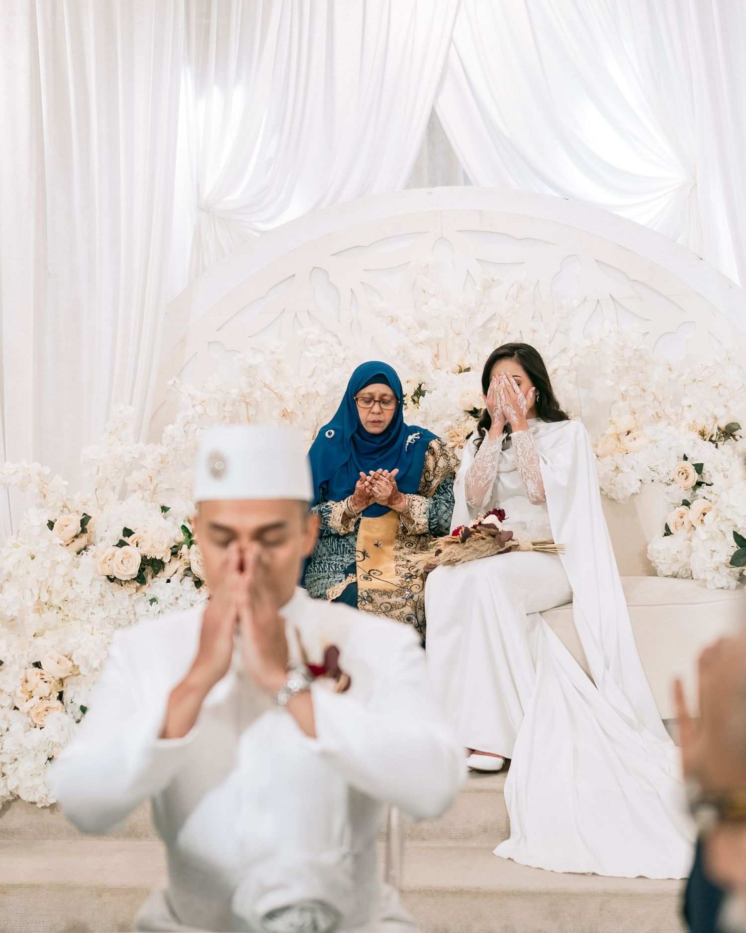A traditional Malay wedding ceremony with the couple in elegant white traditional attire exchanging rings at Novotel on Stevens.
