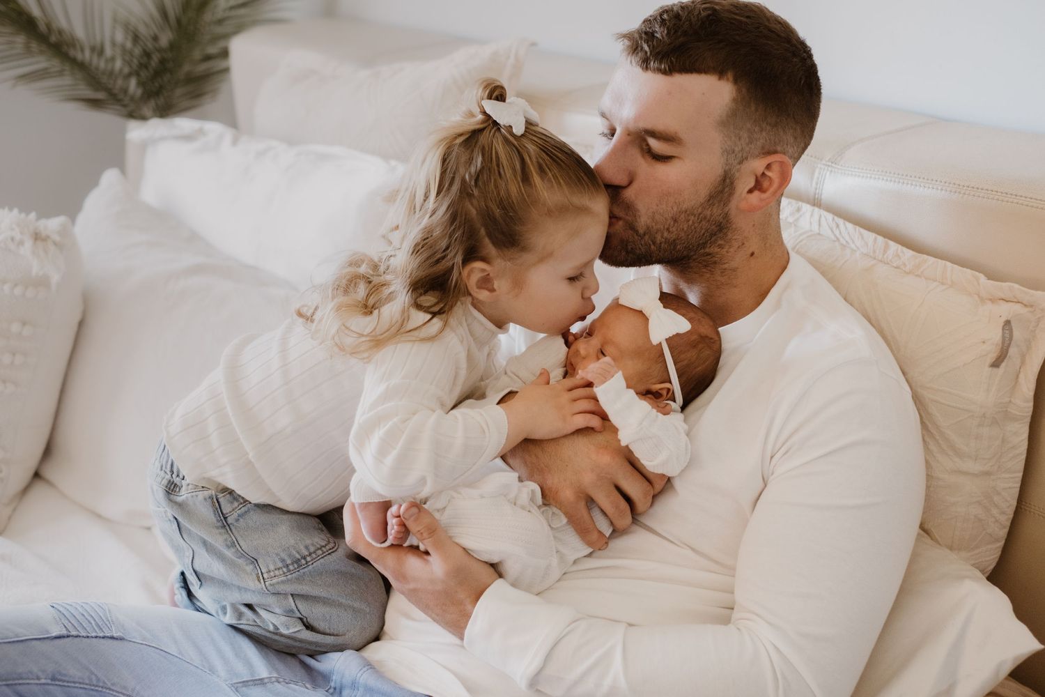 Intimate moment shared on a cozy white couch with warm lighting.