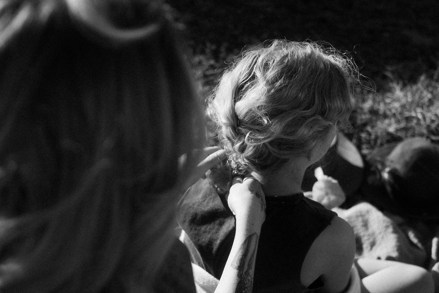 Black and white candid photograph showing movement and natural light outdoors.