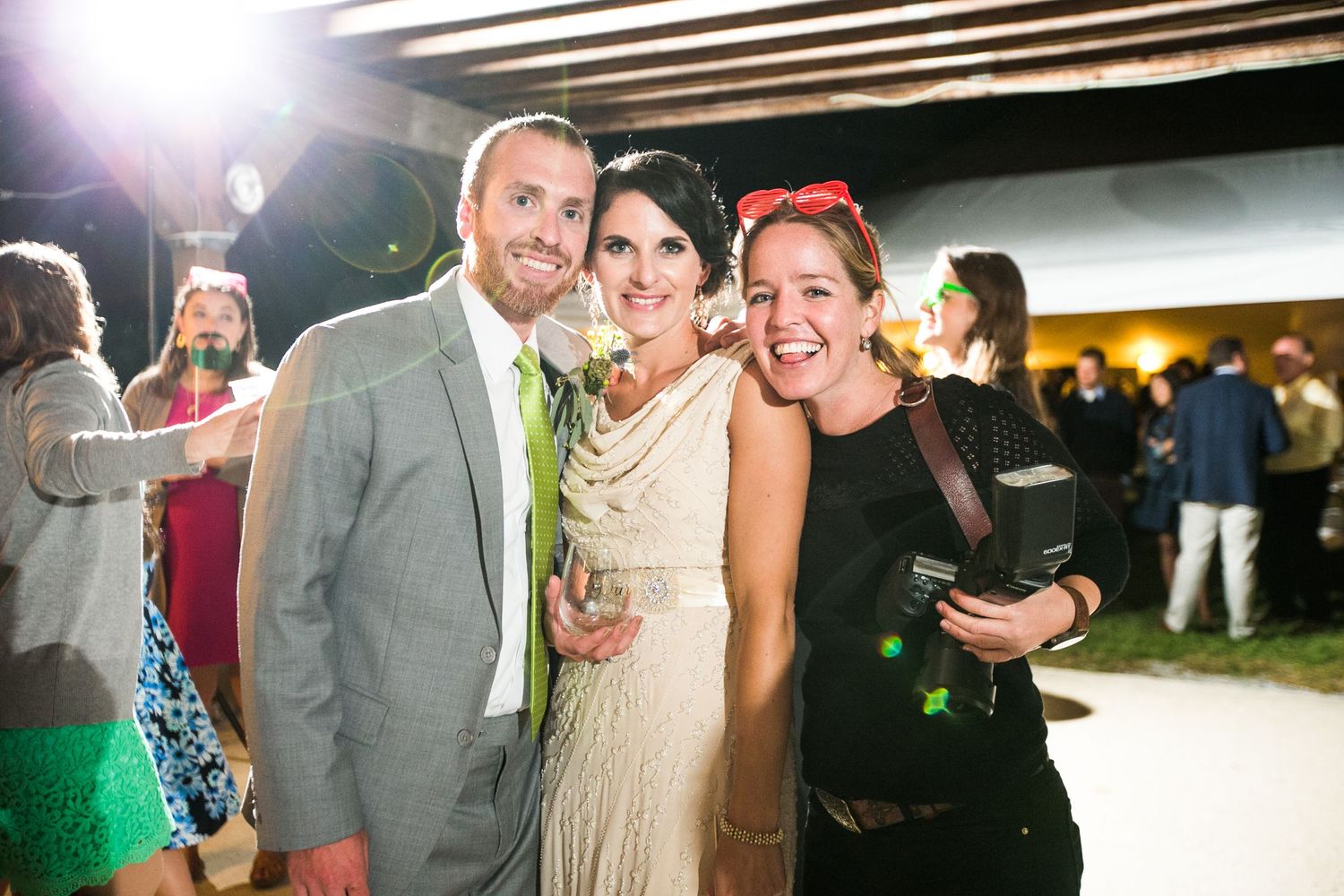 Wedding guests dancing and celebrating together on a lively dance floor at an indoor reception venue.