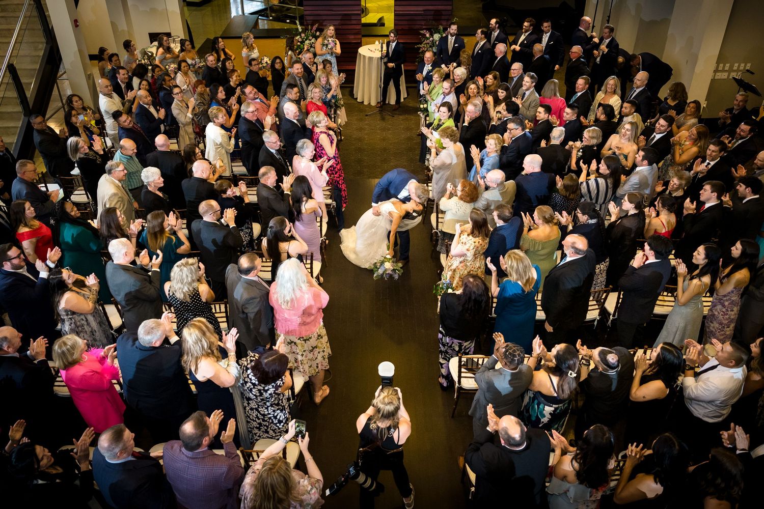 Aerial view of a crowded wedding reception with guests dancing on the dance floor.