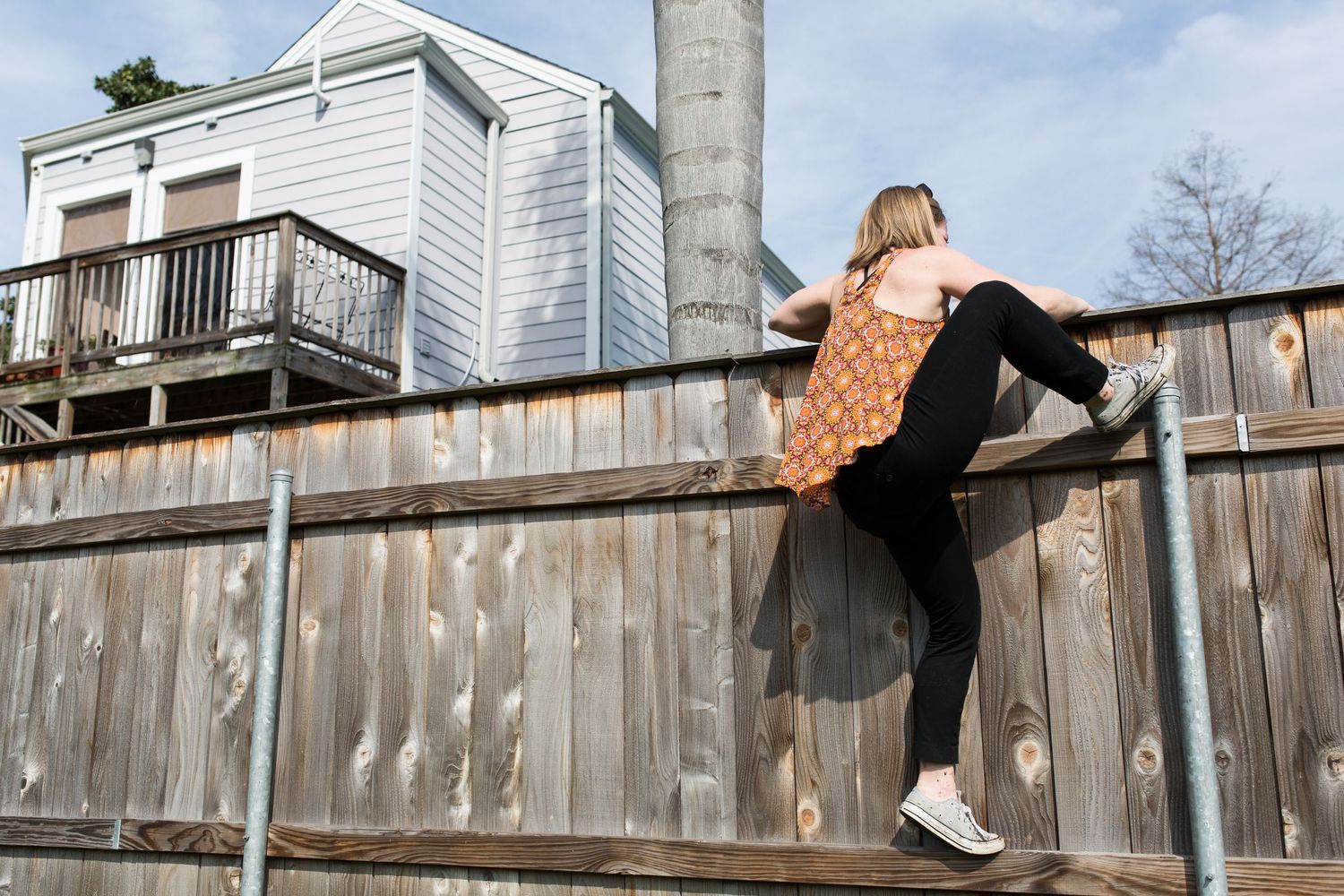 Creative photo sequence showing person jumping over a white wooden fence.