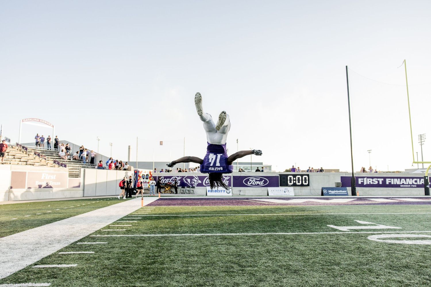 ACU football player performs a celebratory backflip in the end zone after a score.