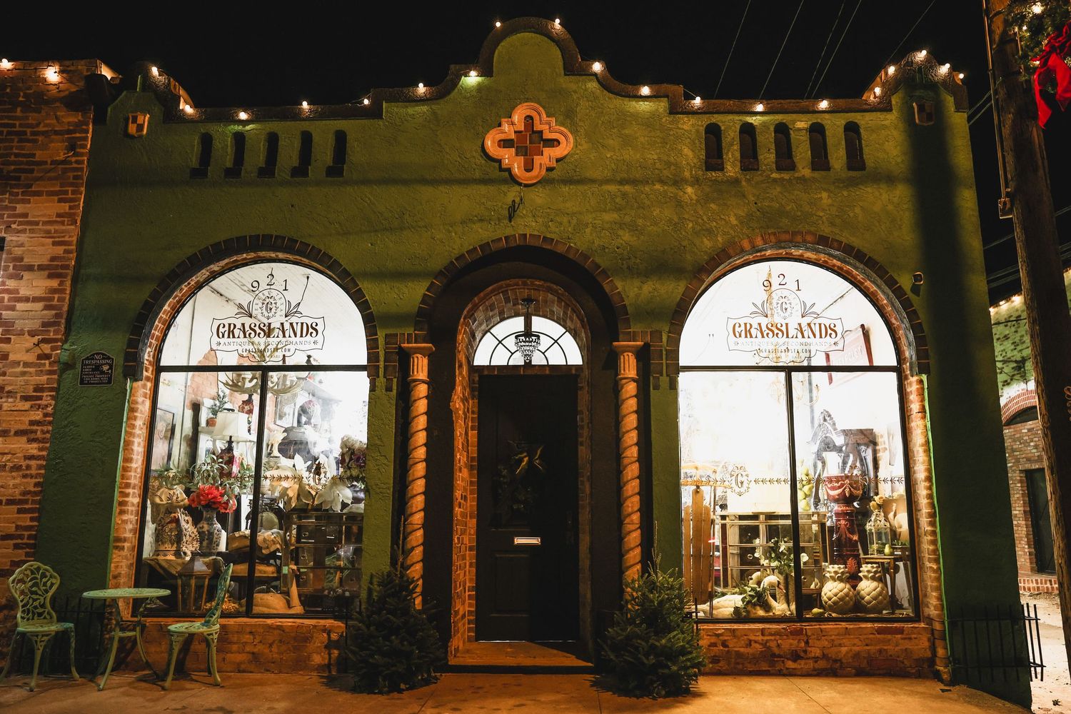 Grasslands restaurant exterior at night with string lights and arched windows.